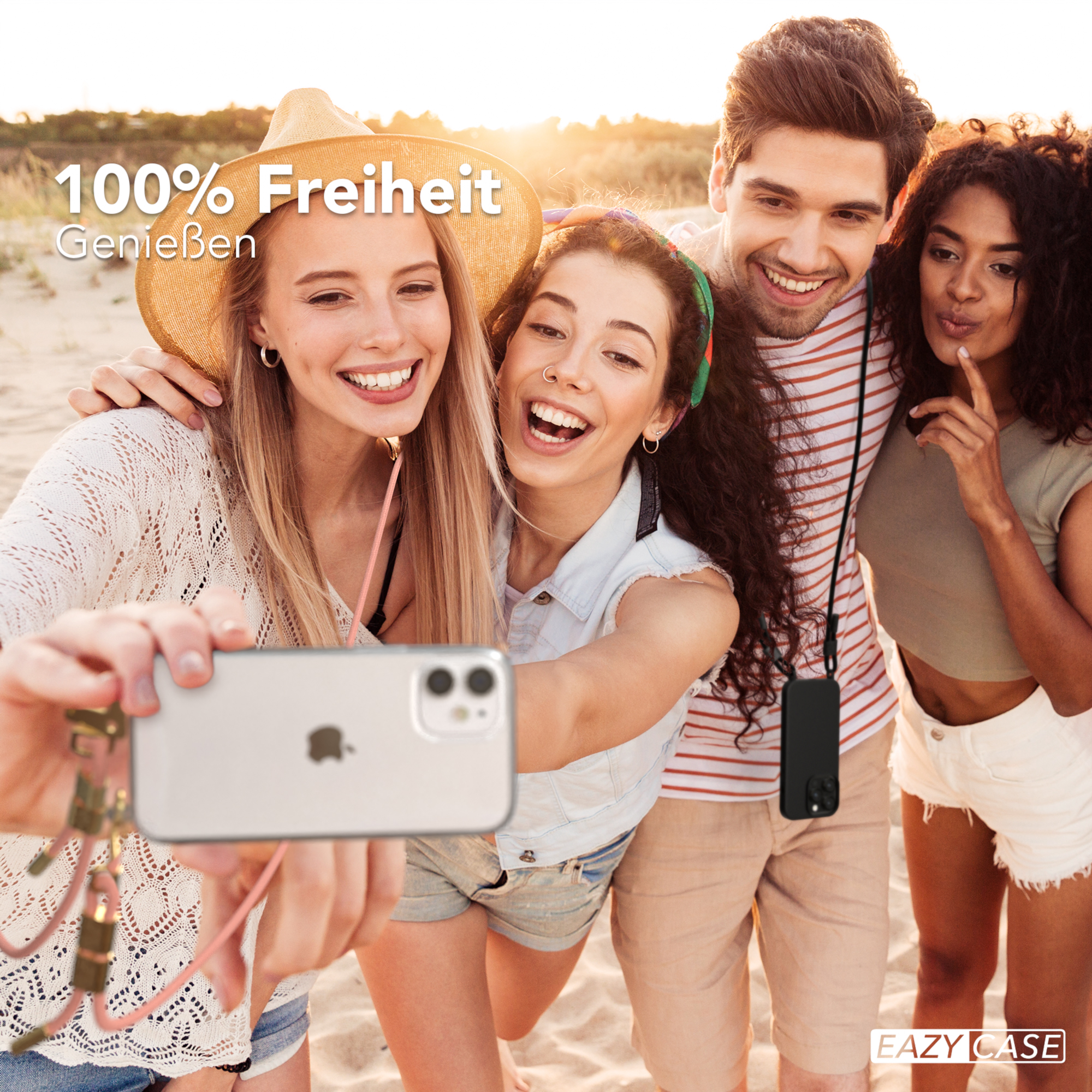 Vier Personen machen ein Selfie, eine trägt ein Telefon-Lanyard. Strandszene mit Sand und Sonne.
