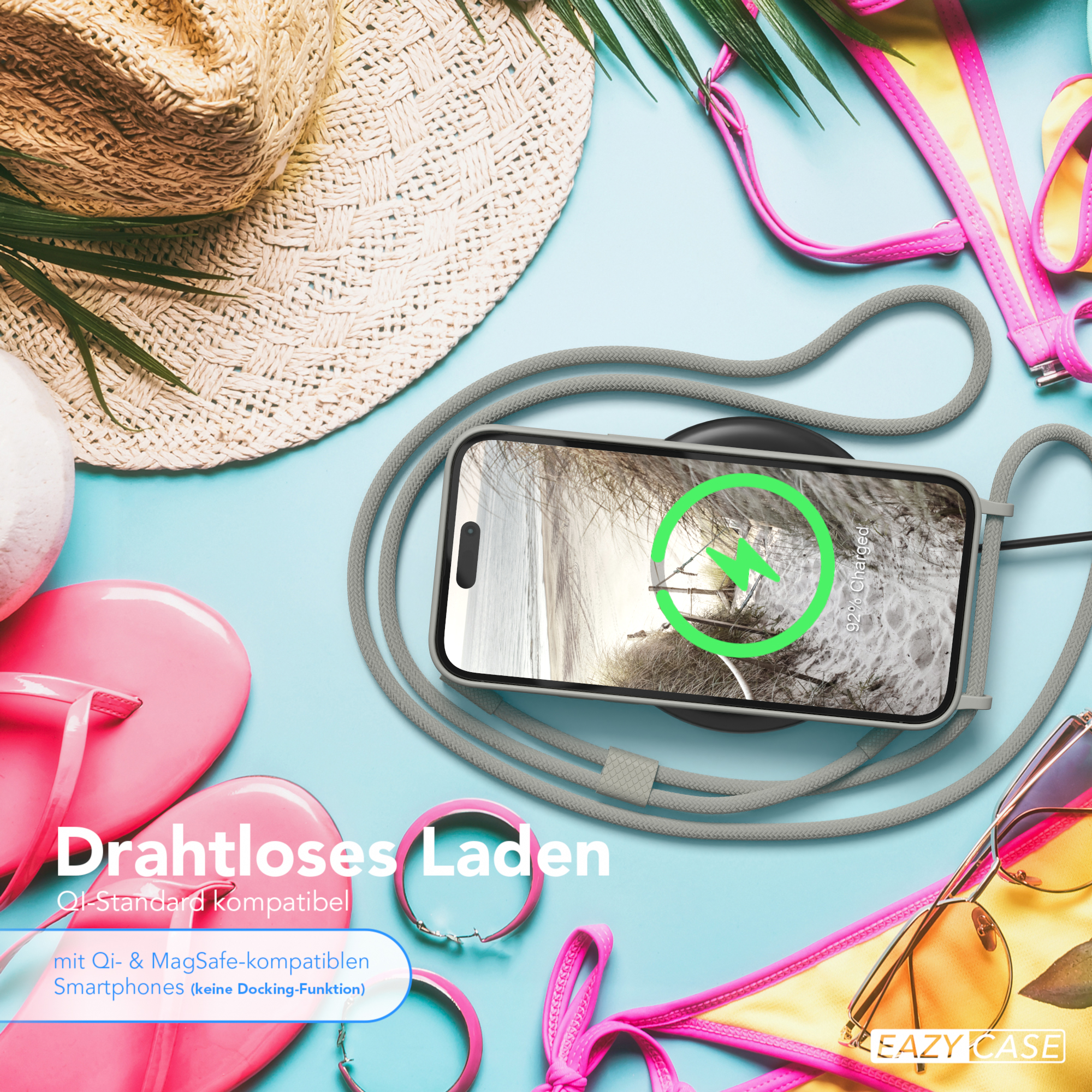 Telefon, das auf einem kabellosen Ladegerät geladen wird, mit Strandaccessoires im Hintergrund.