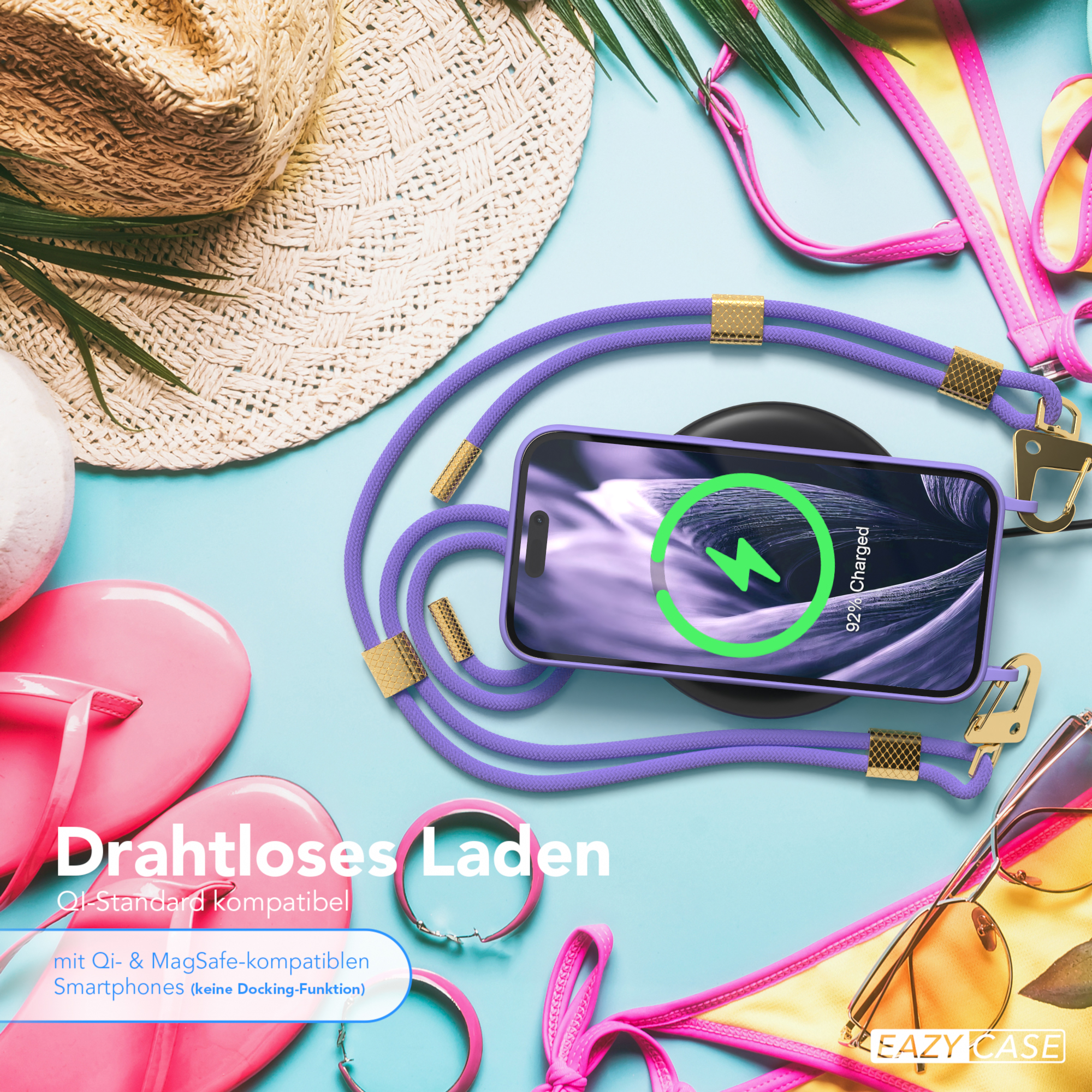Ein Telefon auf einem Ladepad, ein rosa Bikini, Sonnenbrille und anderes Zubehör auf blauer Oberfläche.