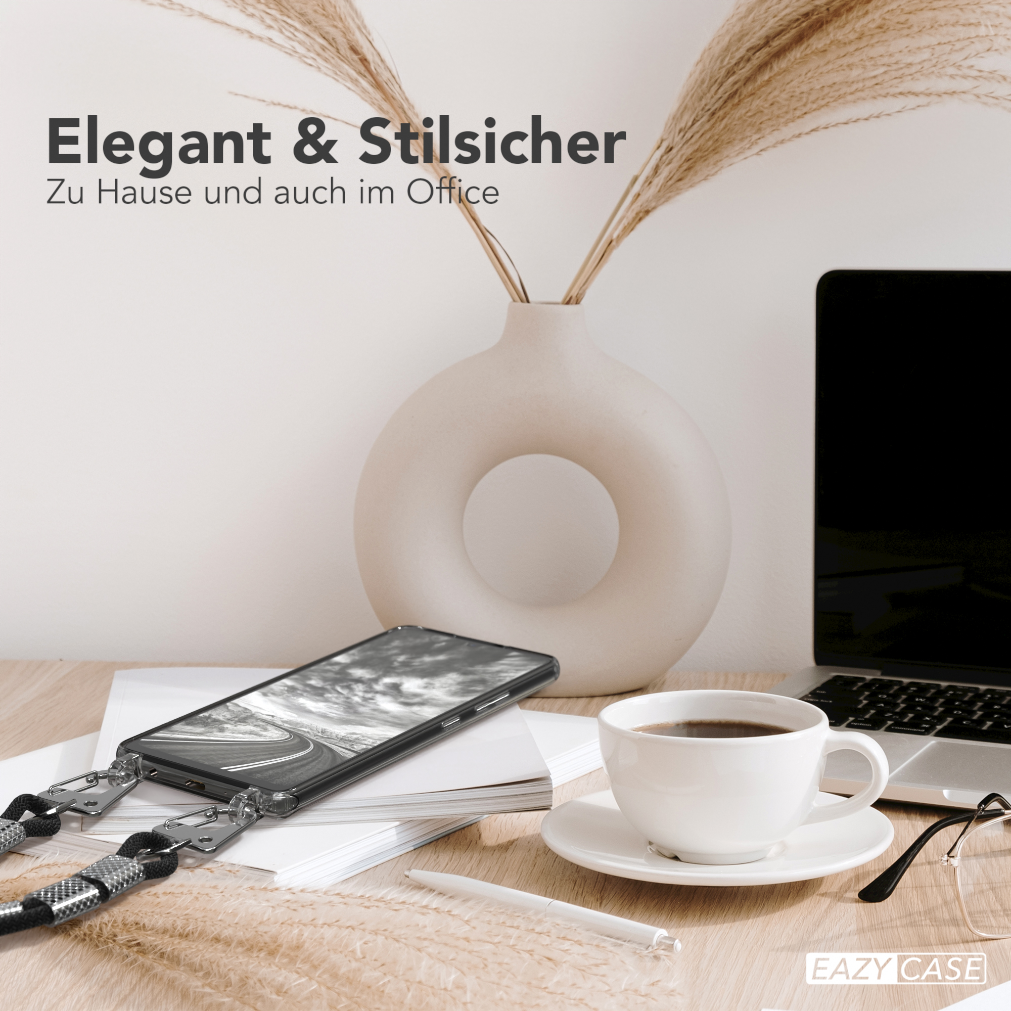 Telefon mit Lanyard, Kaffeetasse, Laptop und Vase mit Pflanzen auf einem Schreibtisch. Büro.