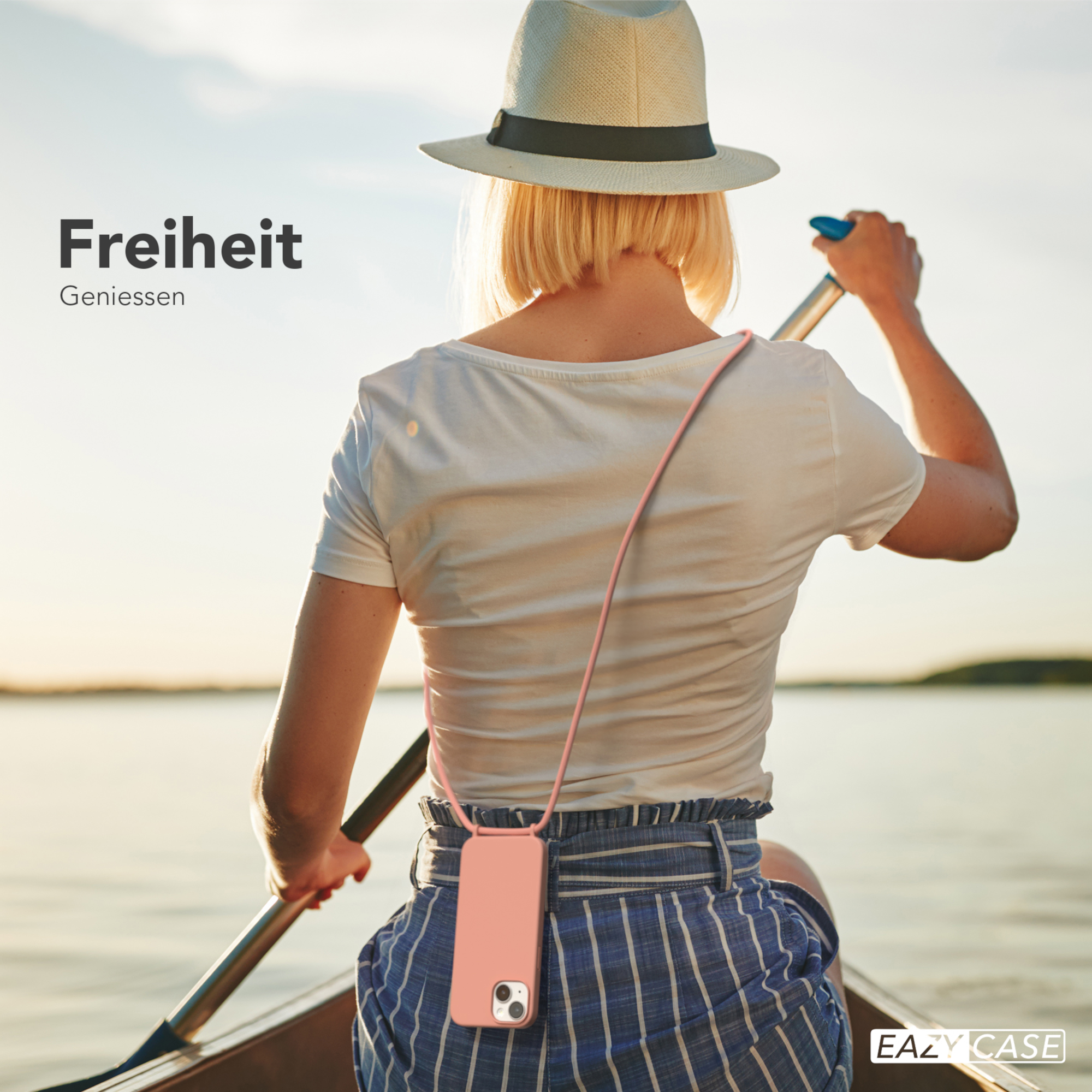 Frau in einem Boot, paddelt mit einem Telefon an einem rosa Band um den Hals.