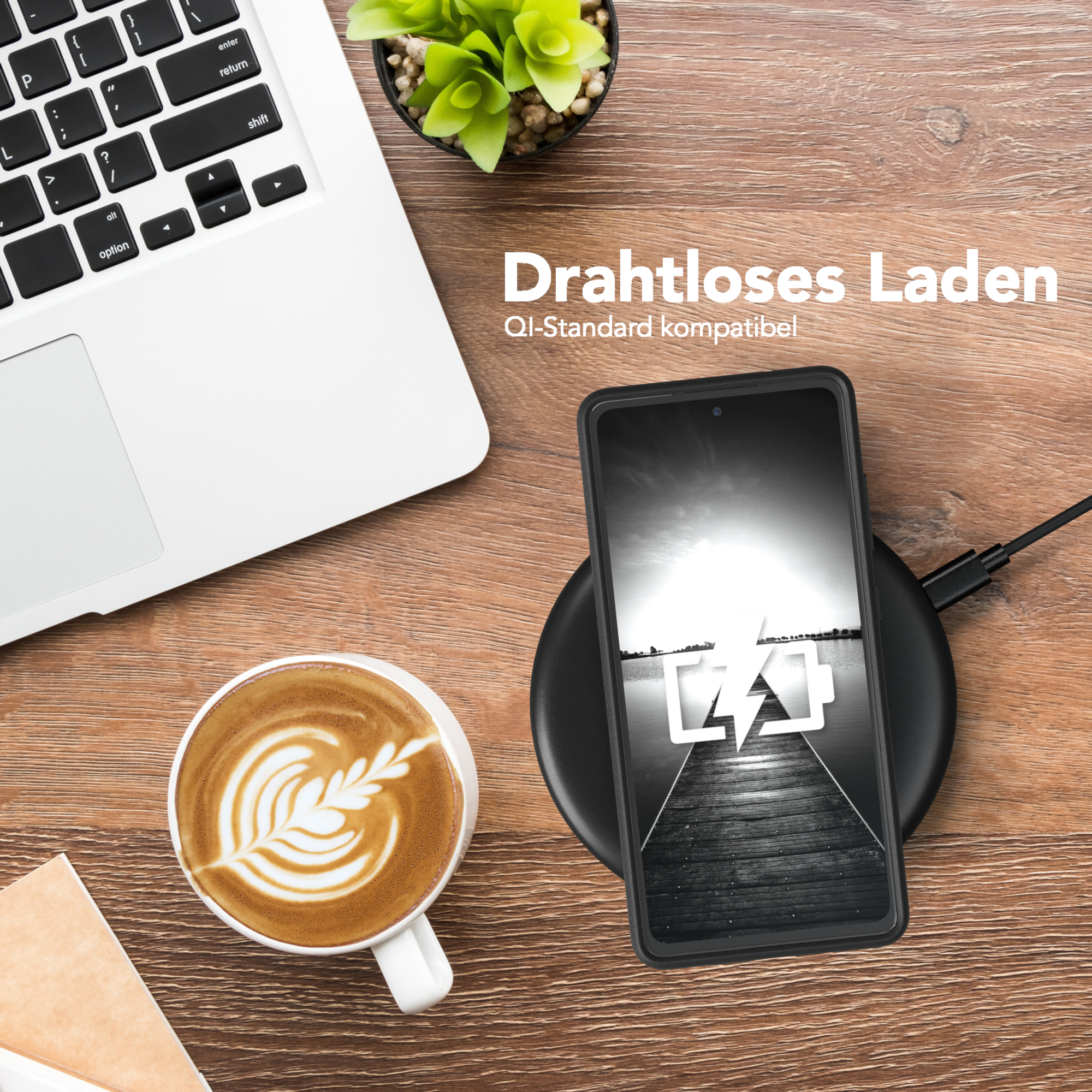 Laptop, Kaffee und kabellose Ladestation mit Telefon. Holztisch. Kleine Pflanze.