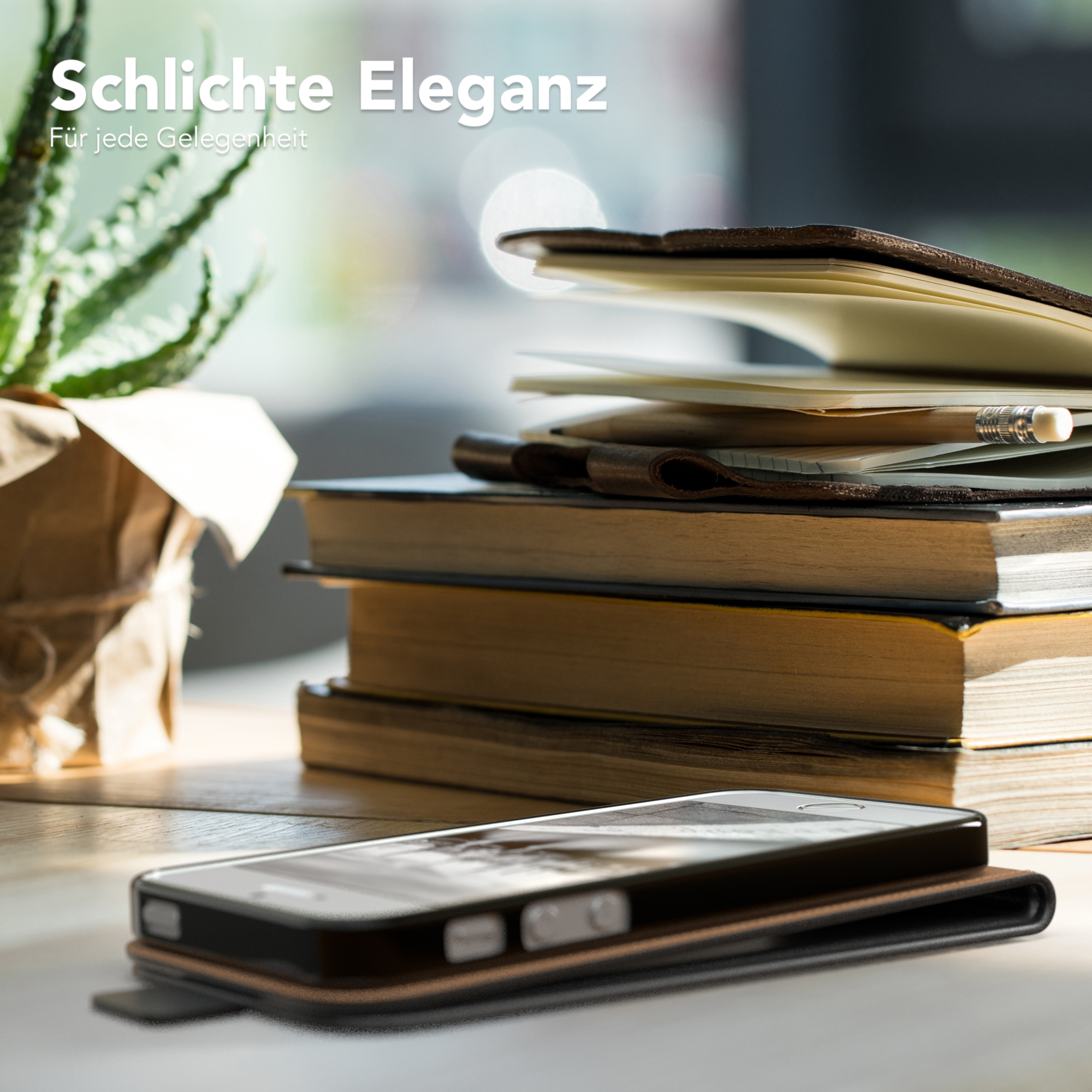 Telefon im Case auf einem Tisch, mit Büchern und einer Pflanze, das Case ist offen, das Telefon zeigend.