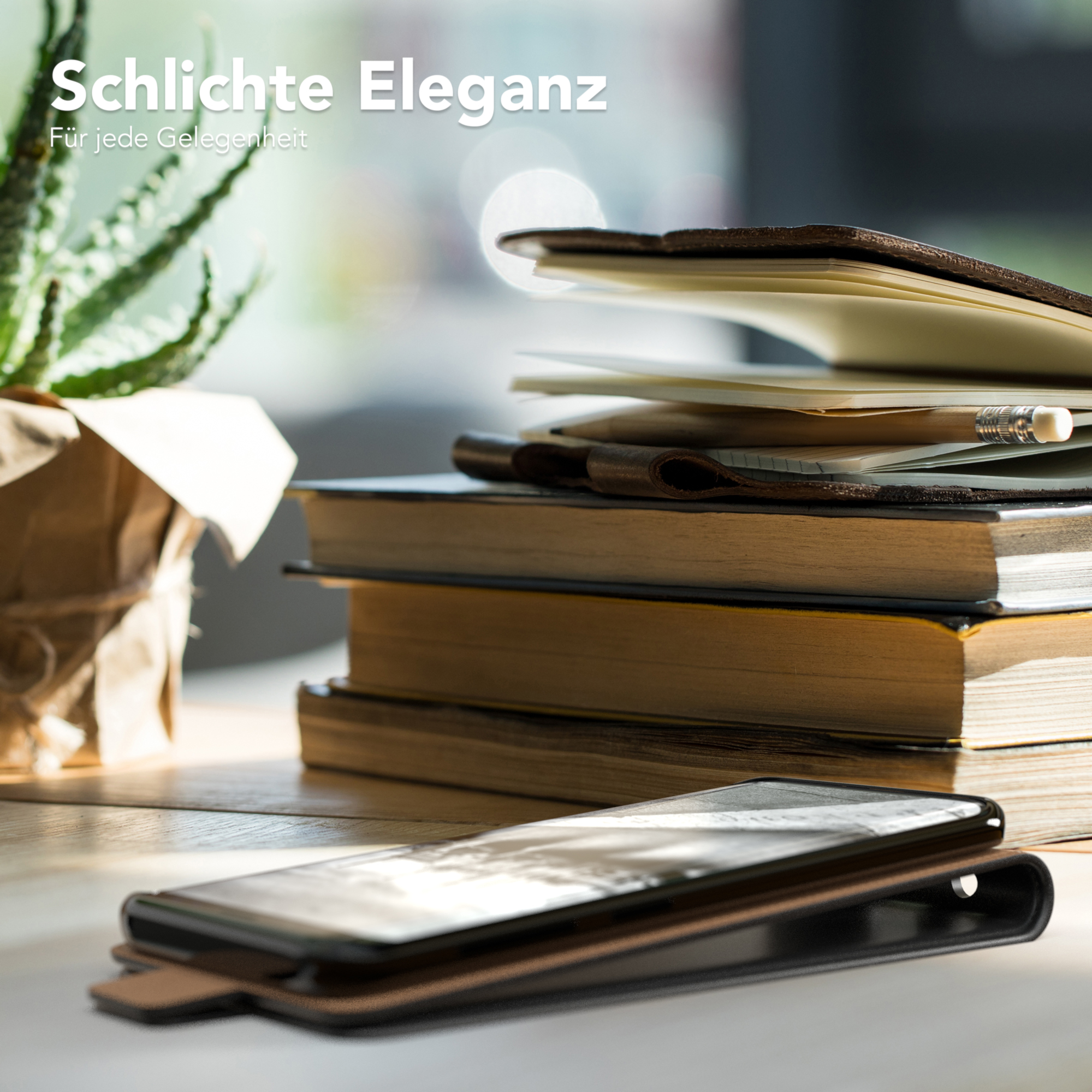 Telefon in brauner Lederhülle auf einem Tisch mit Büchern und einer Pflanze. Der Text lautet "Schlichte Eleganz".