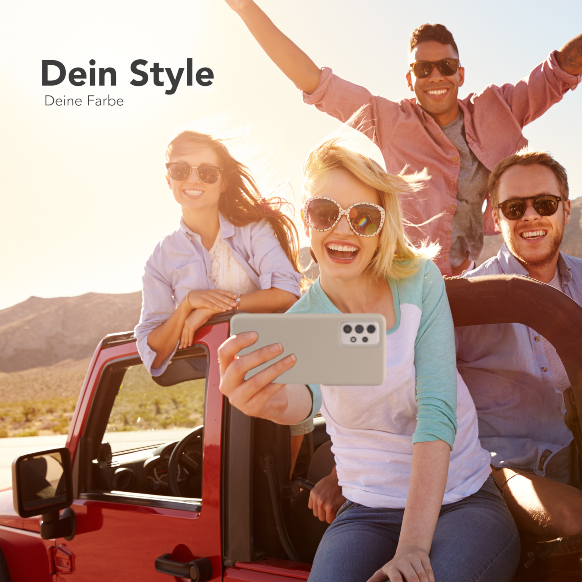 Gruppe von Leuten, die ein Selfie mit einem Telefon machen. Sie sind in einem roten Auto.