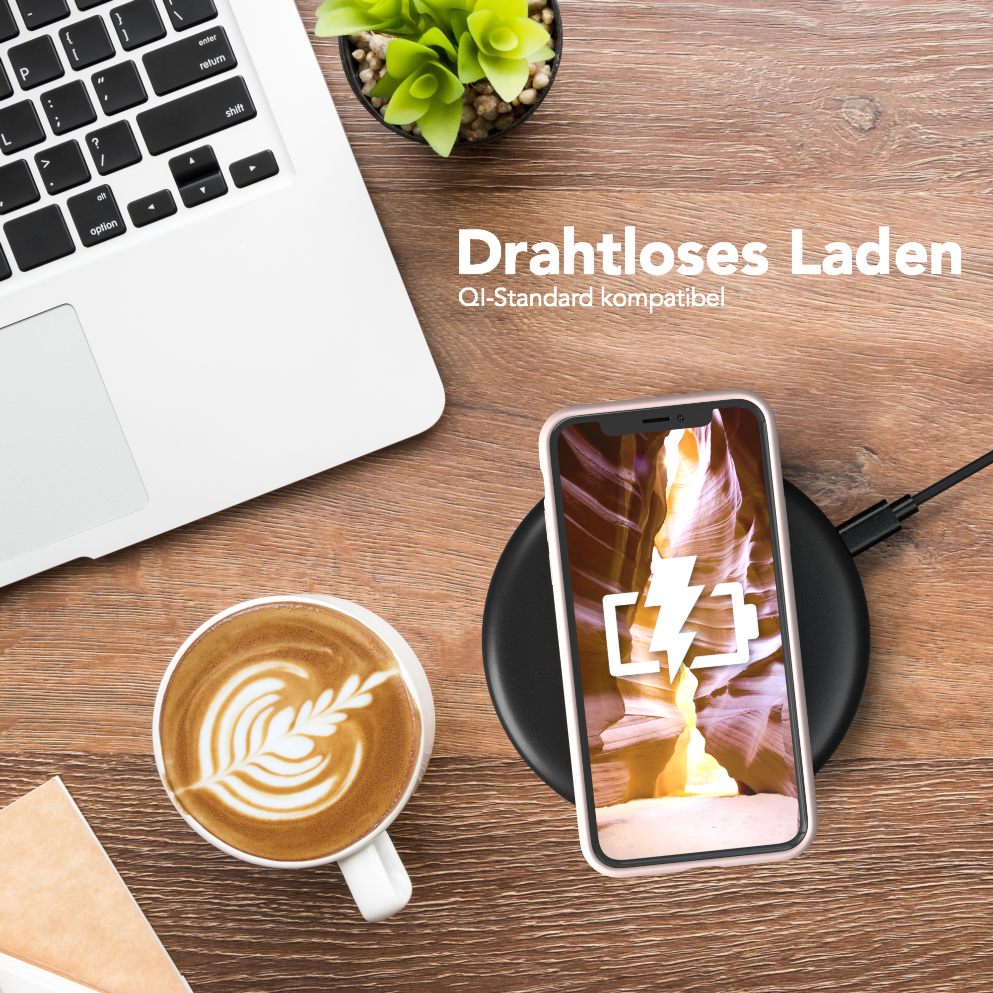 Ein Telefon mit Hülle auf einem kabellosen Ladegerät. Im Hintergrund befinden sich eine Tasse Kaffee und ein Laptop.