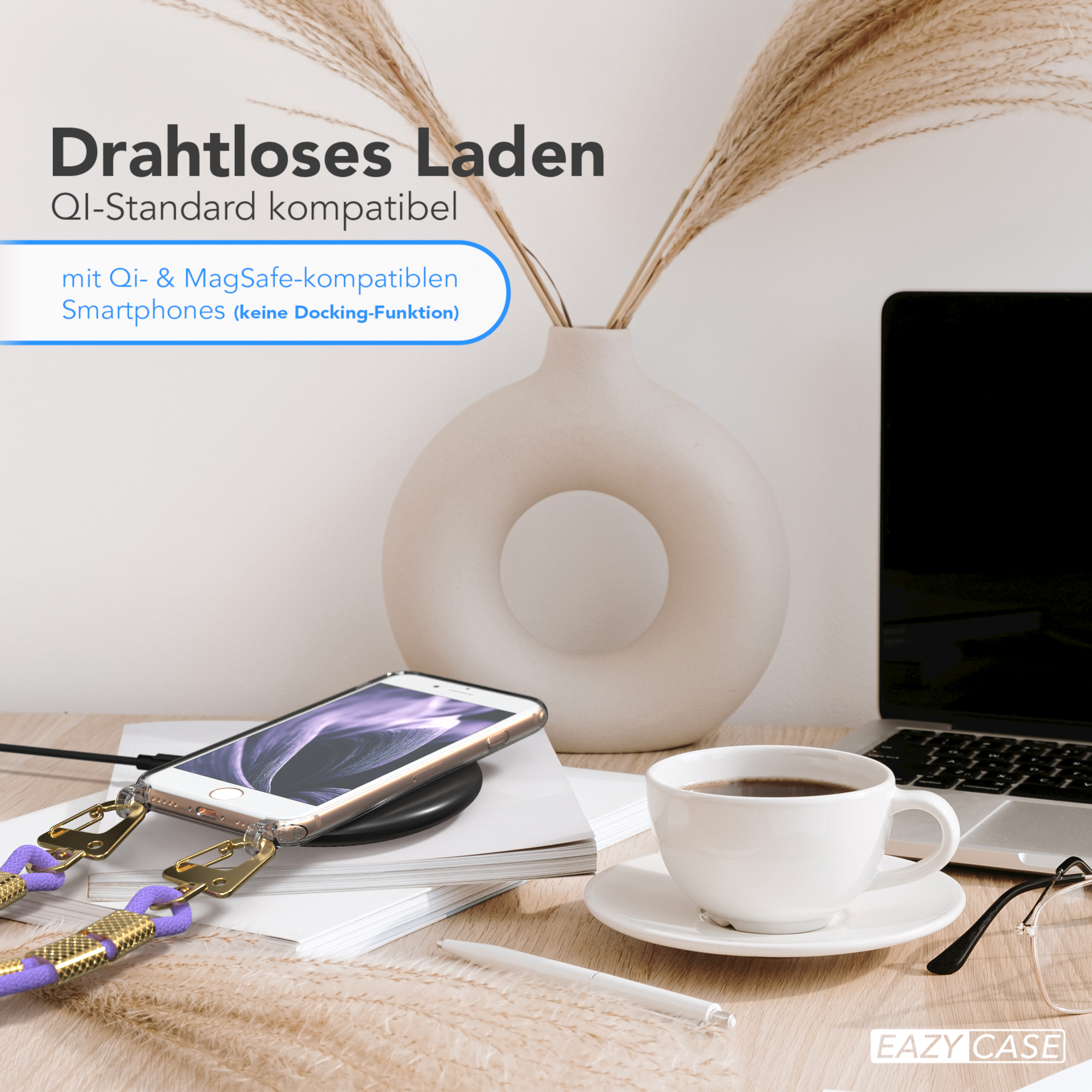 Telefon auf kabellosem Ladegerät, weiße Tasse, Laptop und Vase mit Pflanzen auf Holzschreibtisch.