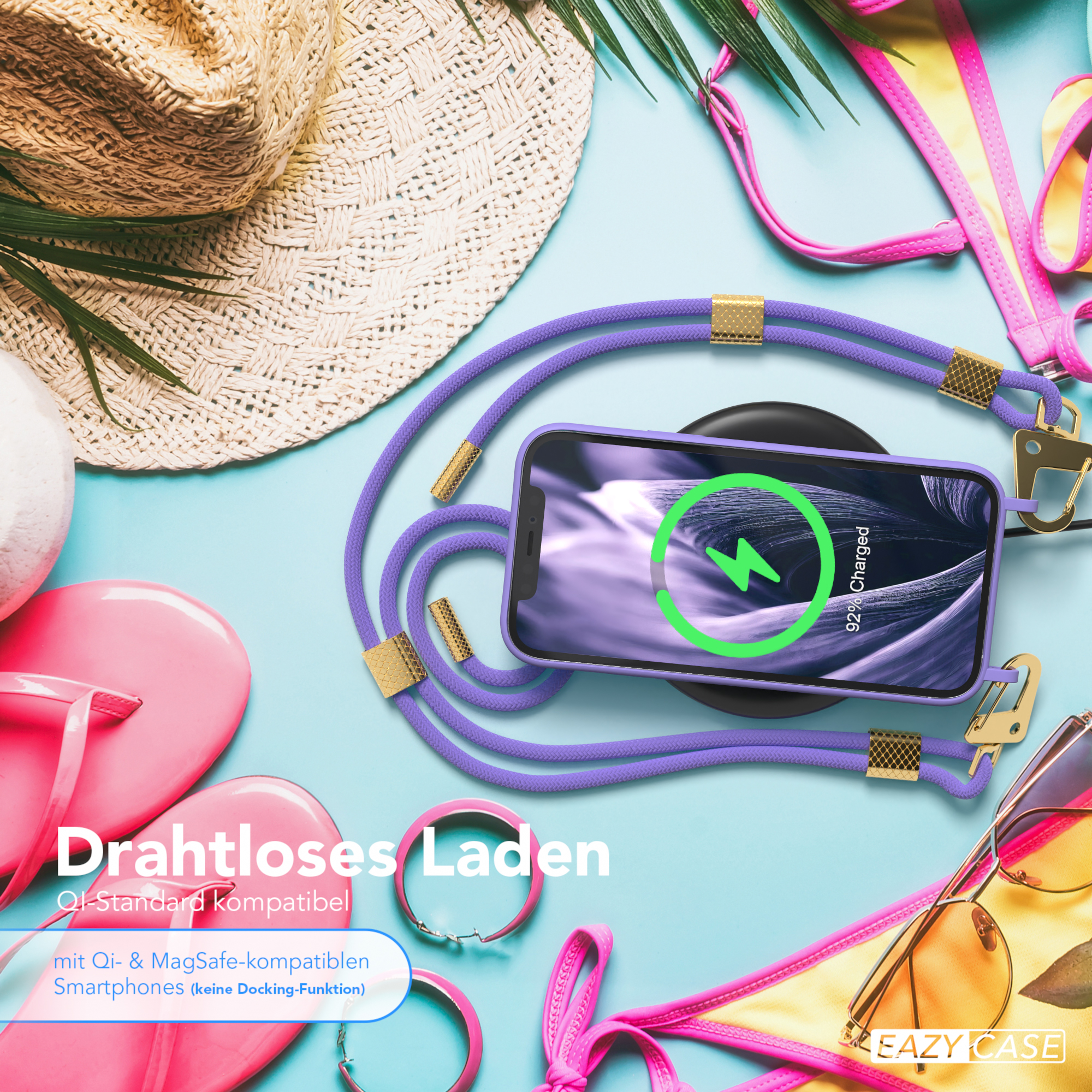 Telefon mit lila Riemen und kabellosem Ladegerät, Strandaccessoires im Hintergrund.