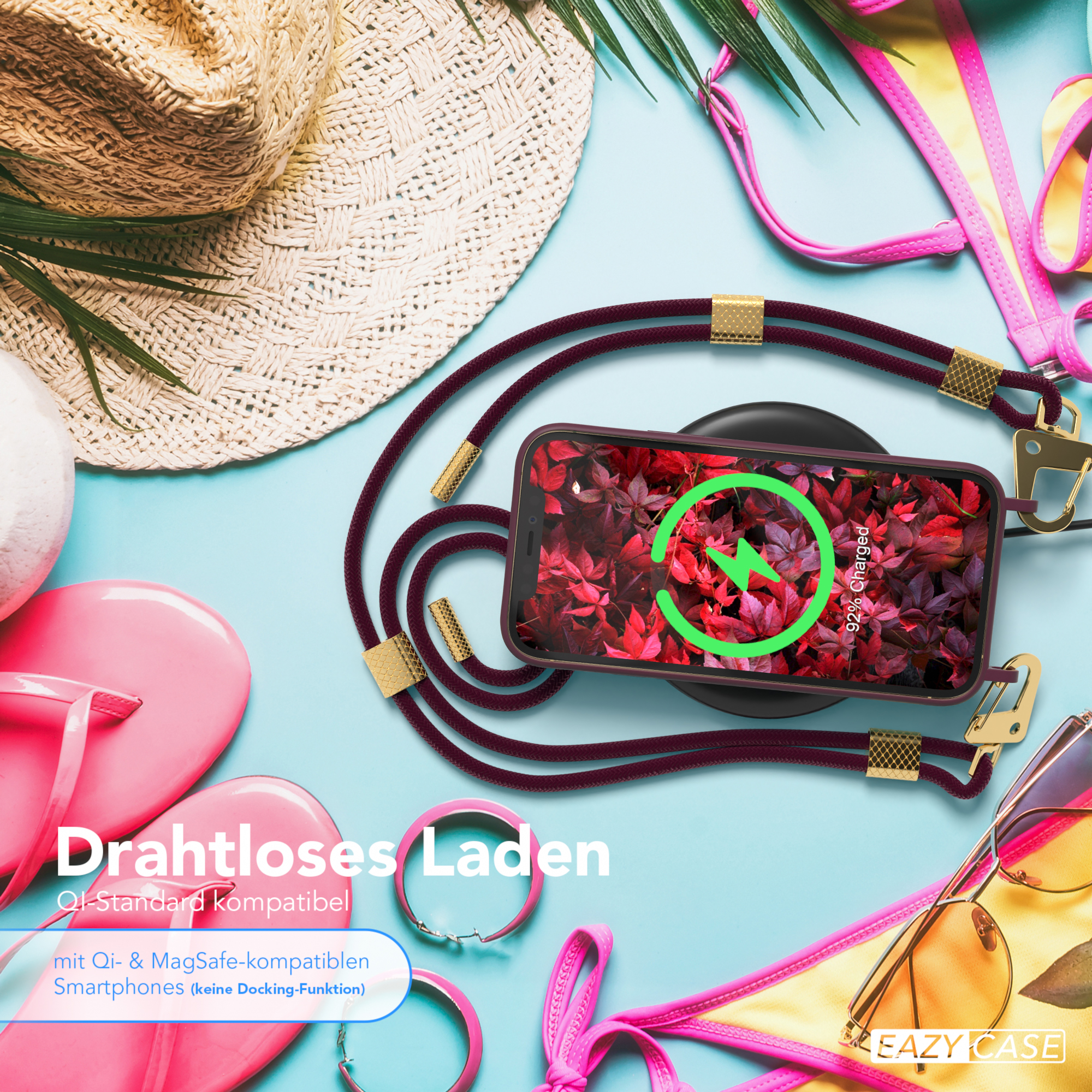 Telefon mit Ladekabel und Zubehör. Auf dem Tisch liegen Bikini und Sonnenbrille.
