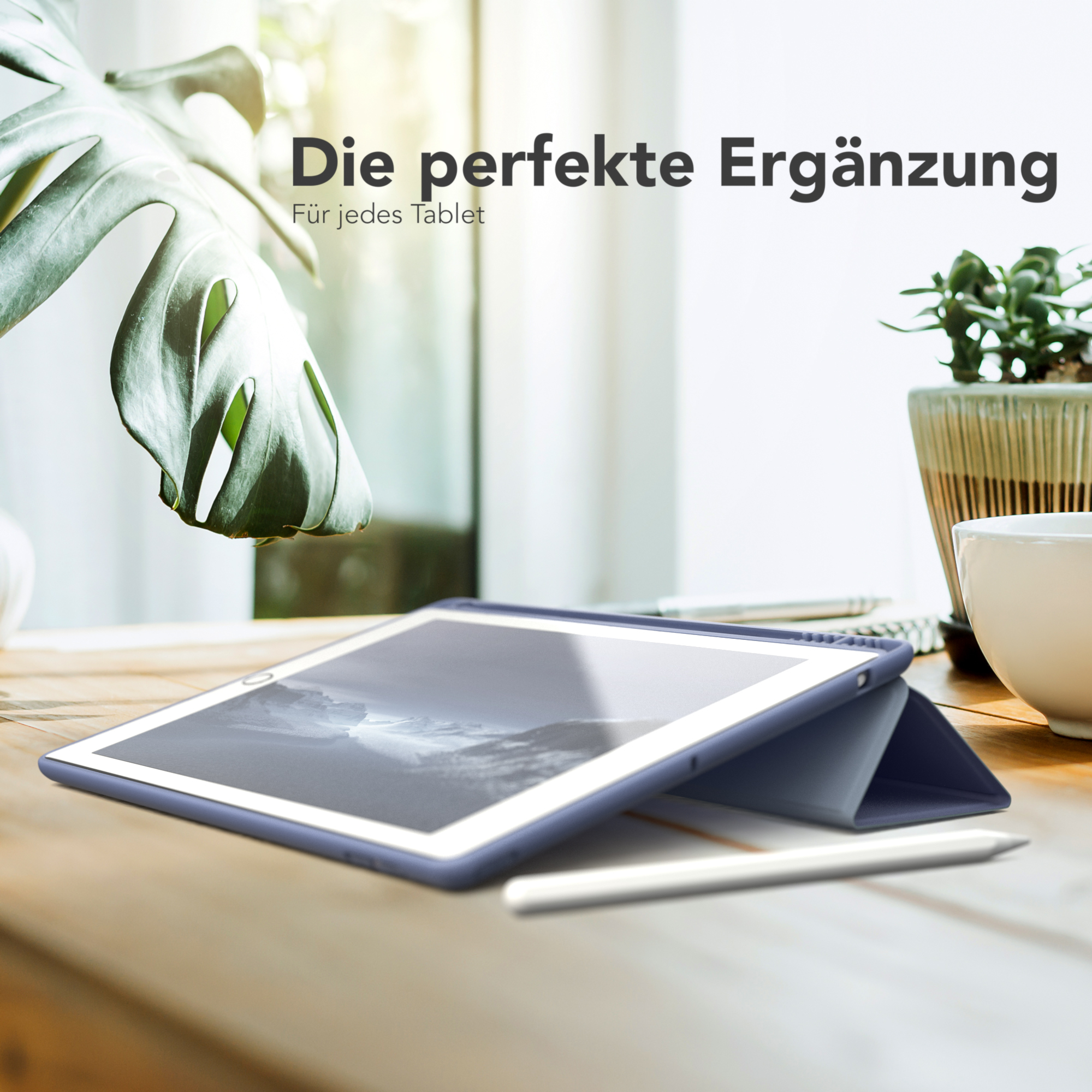 Tablet in einer blauen Hülle auf einem Holztisch, mit Stift und Pflanze im Hintergrund.