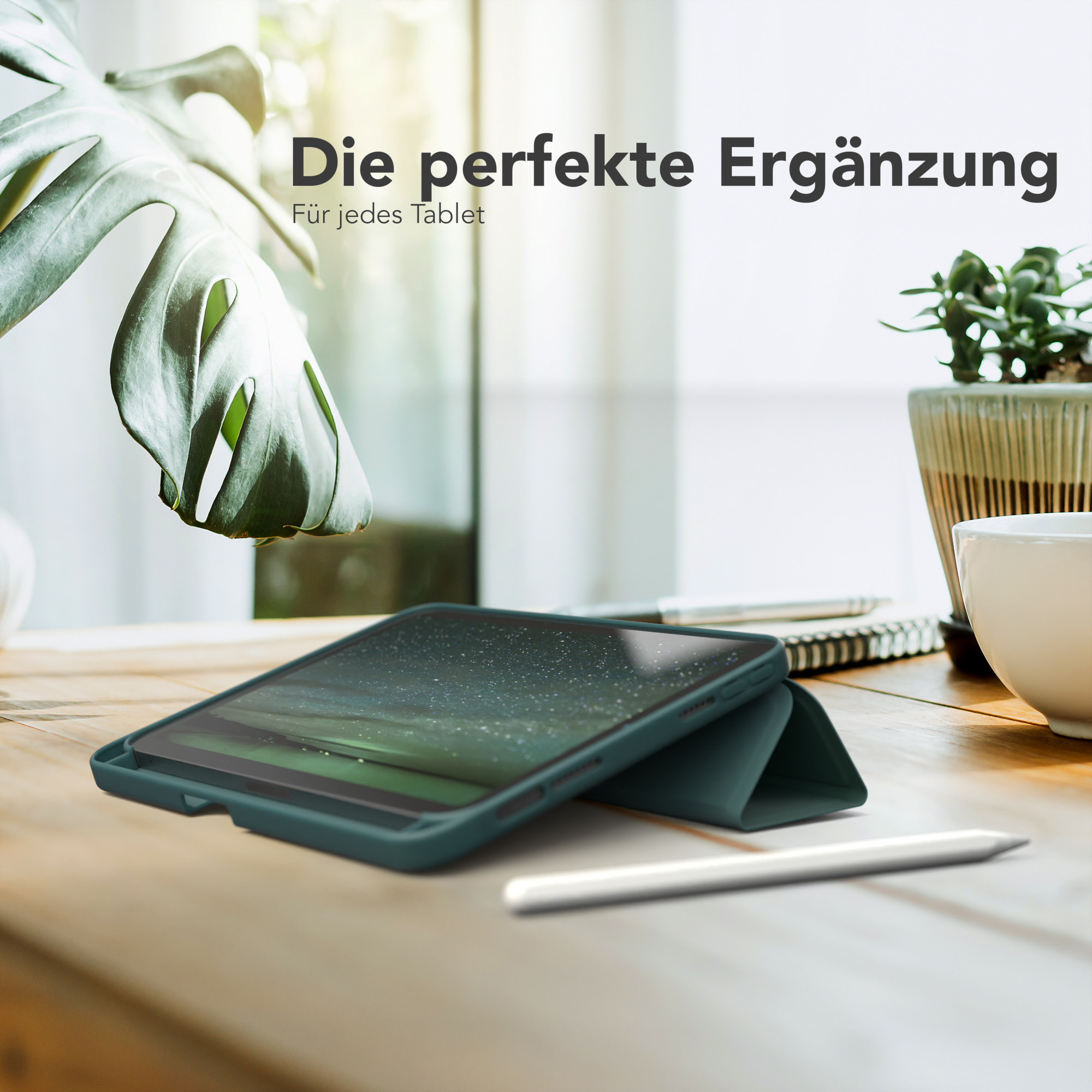 Tablet in einer tealfarbenen Hülle auf einem Holztisch mit Bleistift und Pflanze.