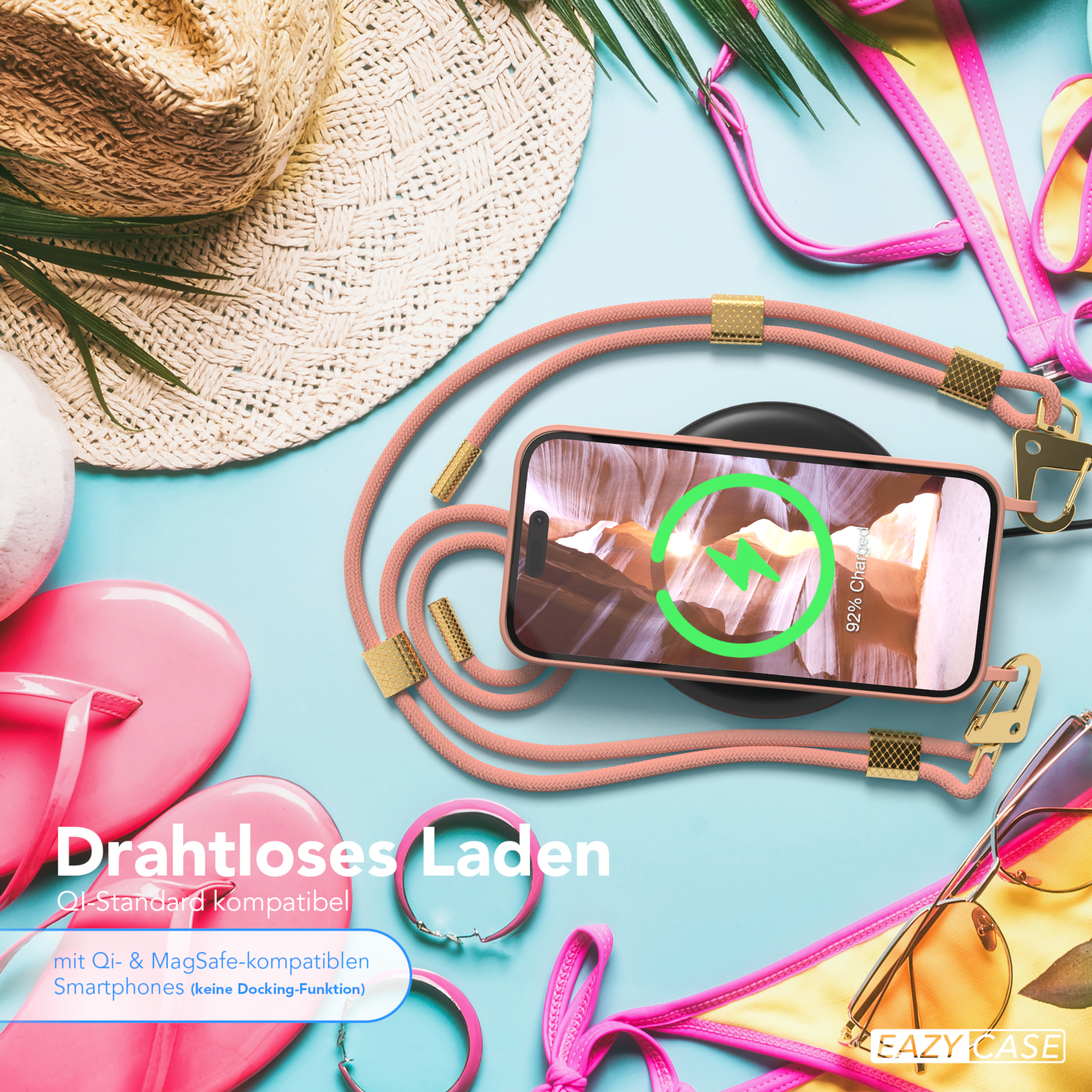 Telefon mit rosa Gurt und Ladegerät, auf blauer Oberfläche.