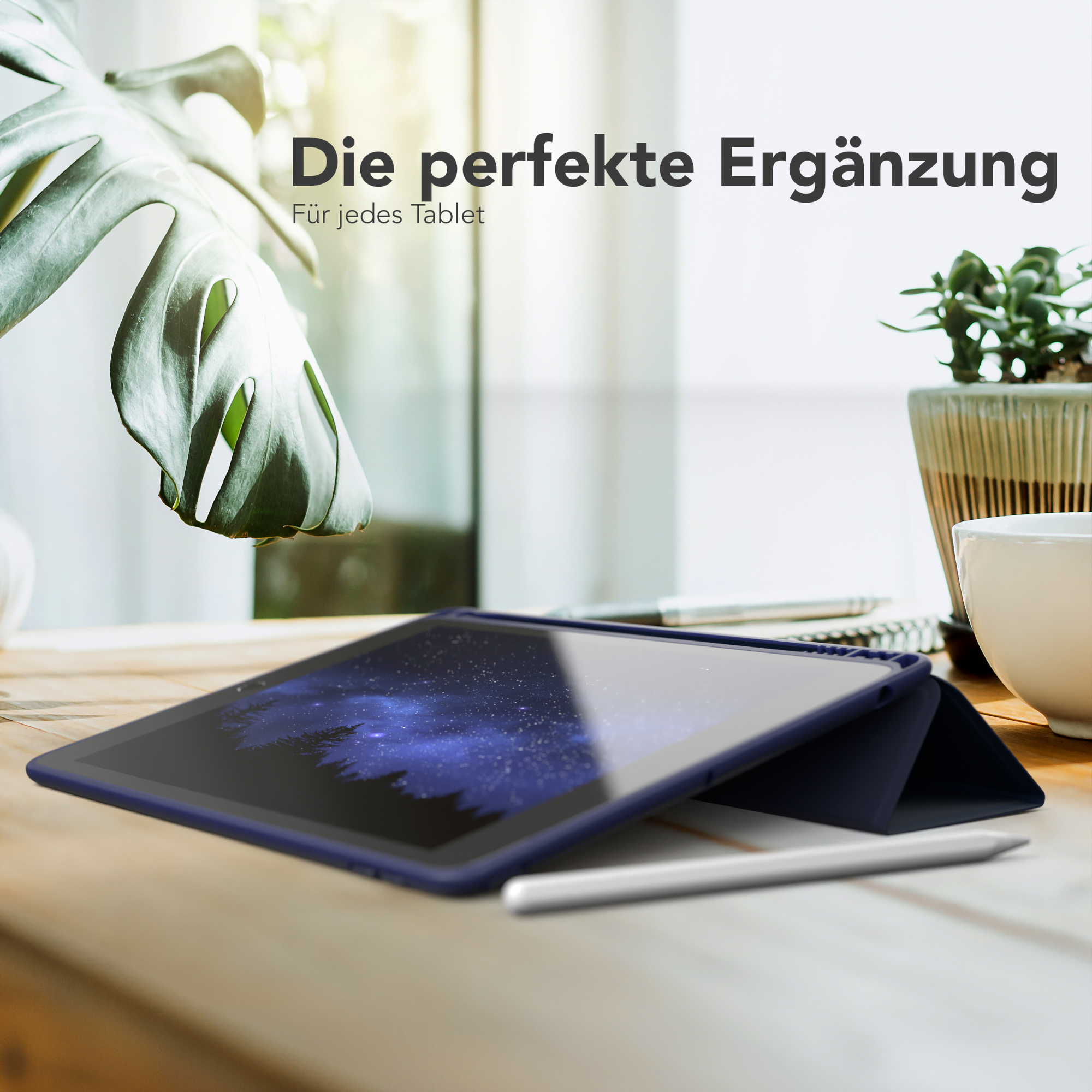 Tablet in einer Hülle, mit Stift und Pflanze auf einem Holztisch, in einem gut beleuchteten Raum.