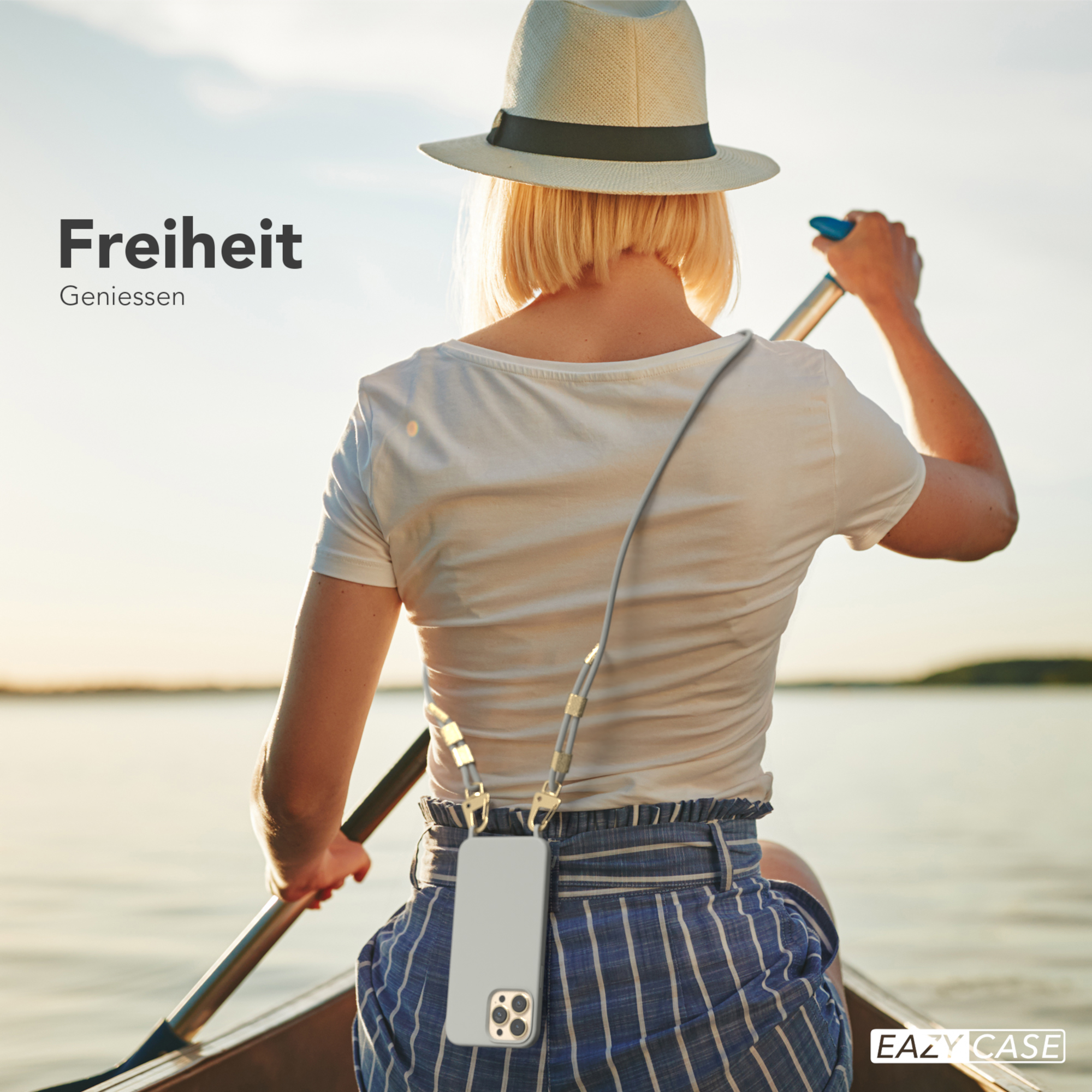 Frau im Boot auf einem See, Ruder haltend. Ein Telefon ist an ihrem Hals befestigt.