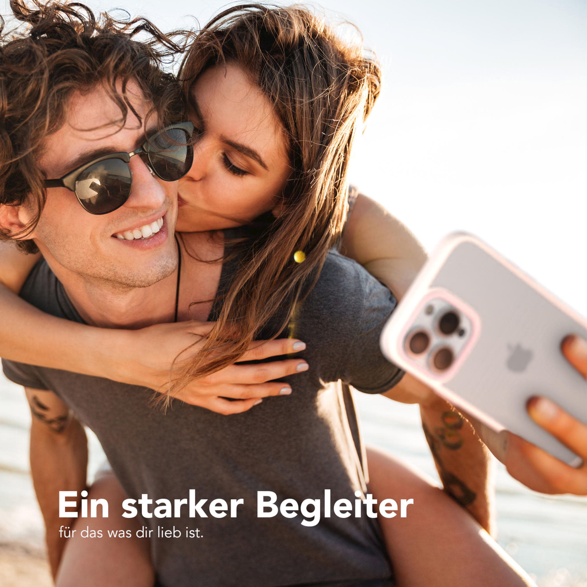 Ein Paar macht ein Selfie. Die Frau küsst den Mann auf die Wange.