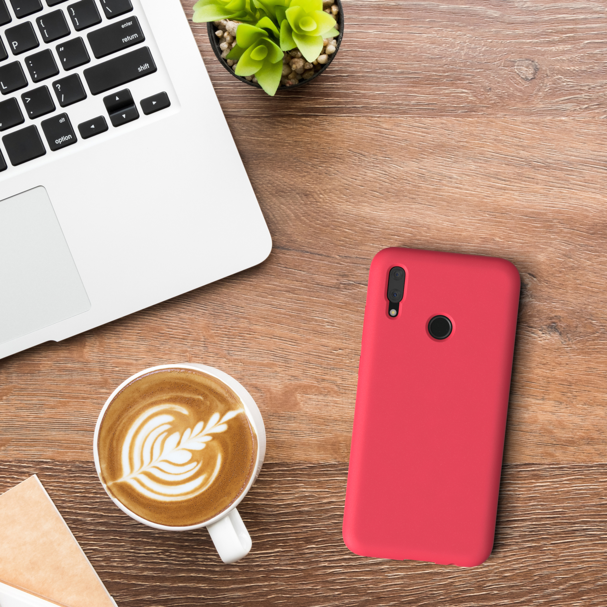 Rote Handyhülle, weißer Laptop, Kaffeetasse mit Latte Art, kleine Pflanze, Holztisch.