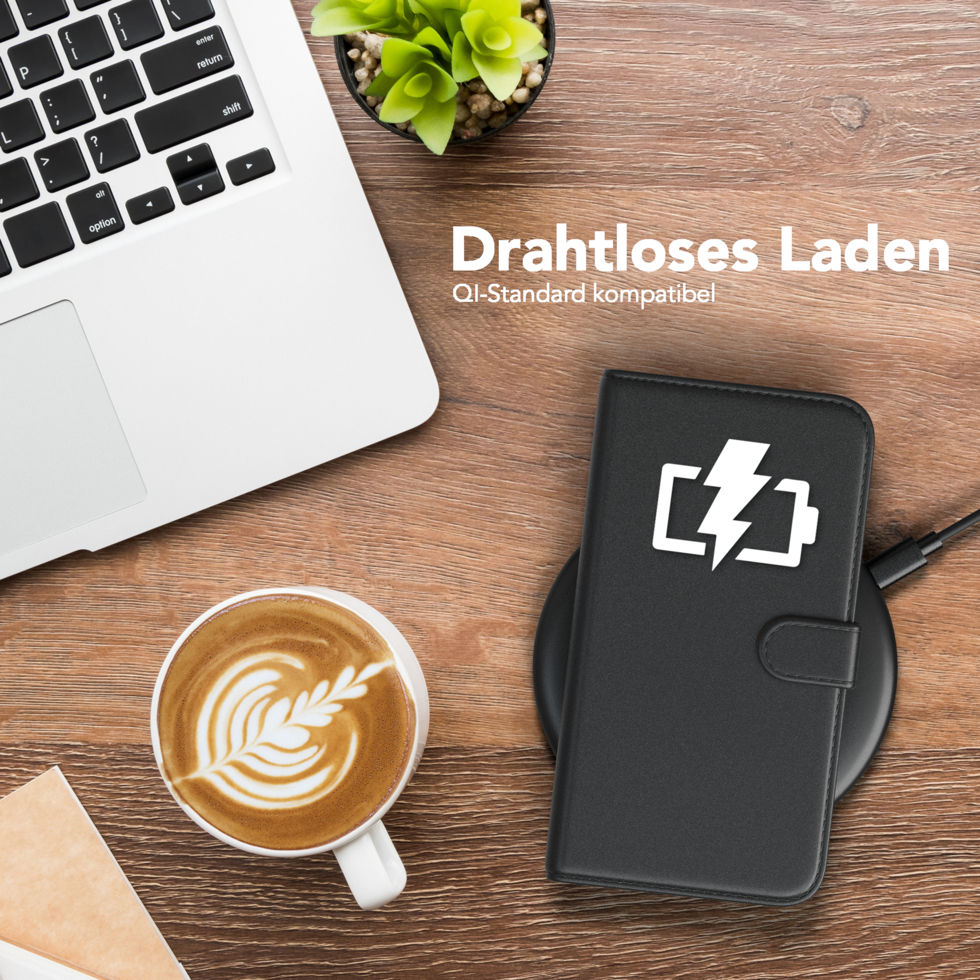 Laptop, Kaffee mit Latte Art, Telefon in schwarzer Hülle auf kabellosem Ladegerät, Holztisch.