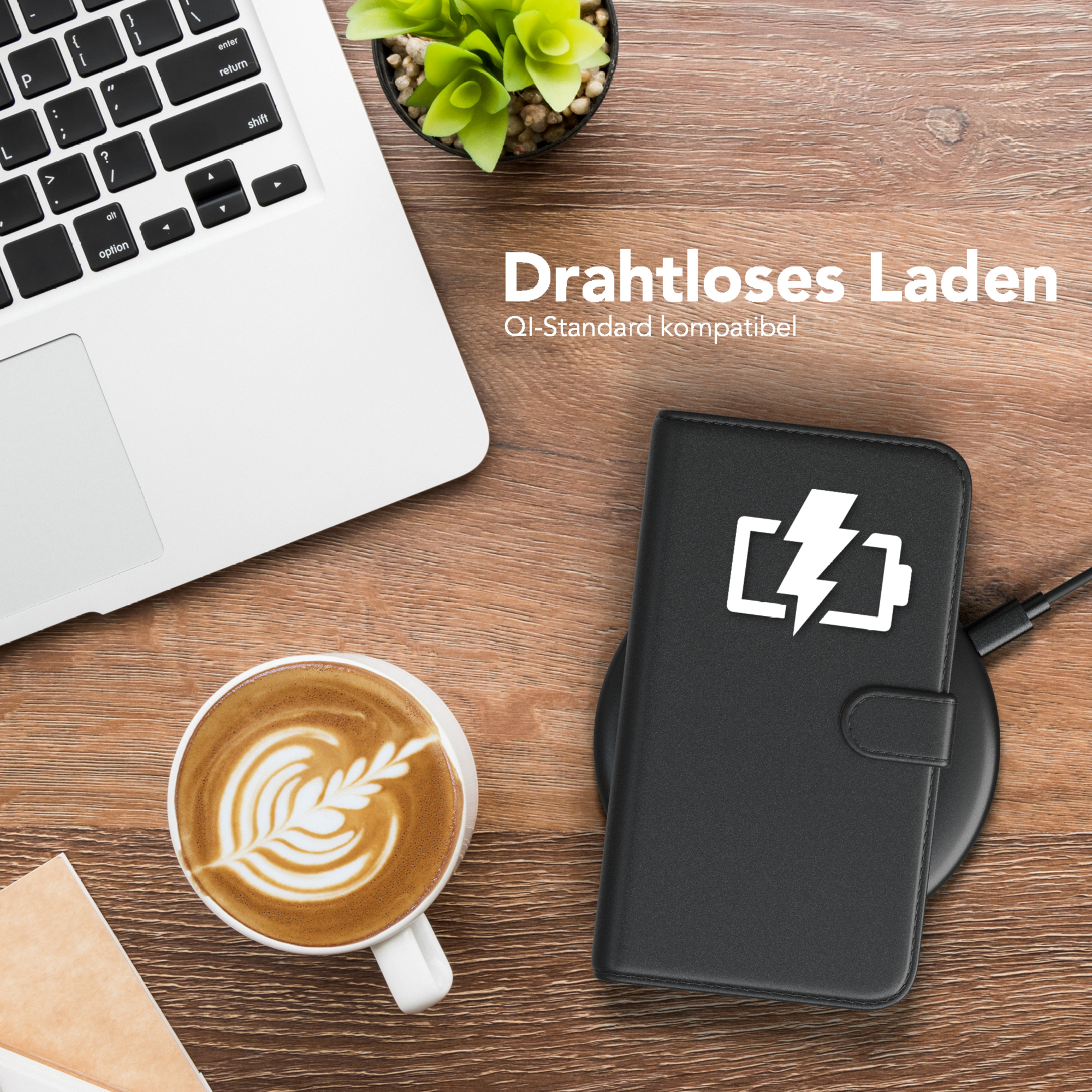 Ein Laptop, eine Tasse Kaffee und ein Telefon, das drahtlos auf einem Pad geladen wird.