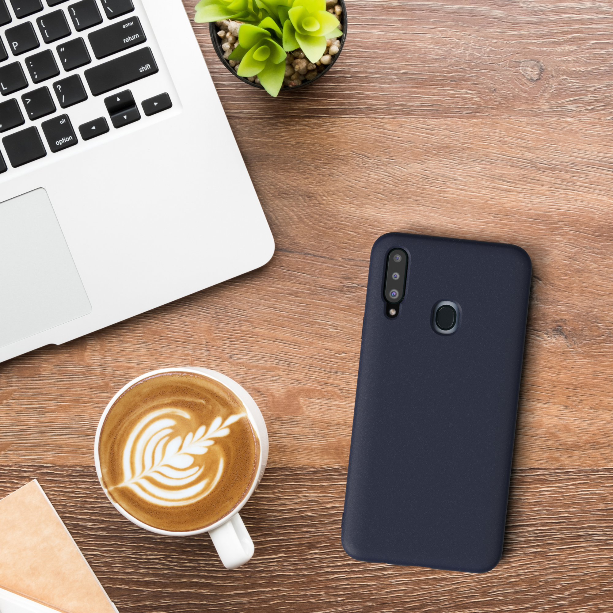 Laptop, Kaffee und eine Handyhülle auf einem Holztisch.