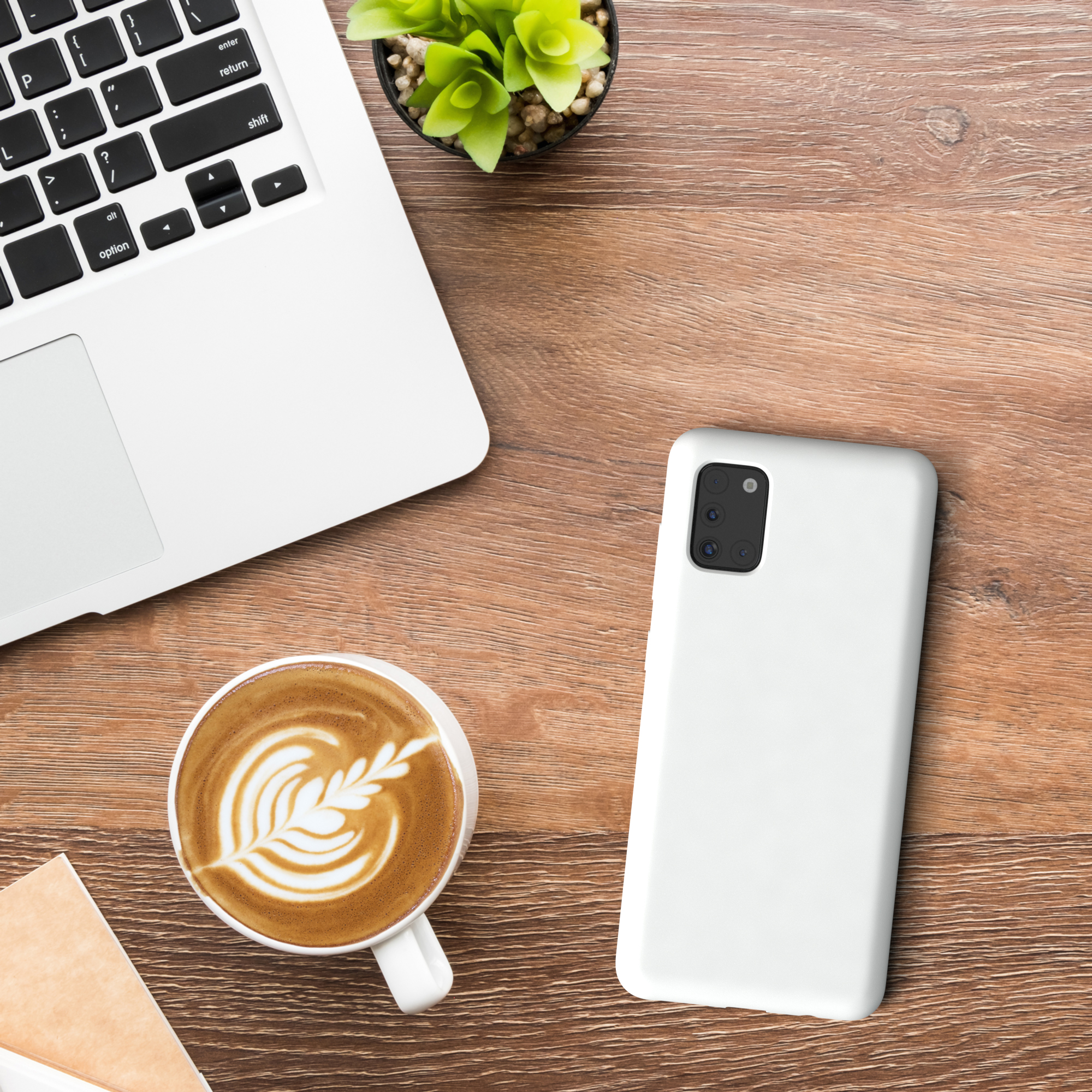 Laptop, Kaffee, Telefon und Pflanze auf Holztisch. Latte Art im Kaffeebecher.
