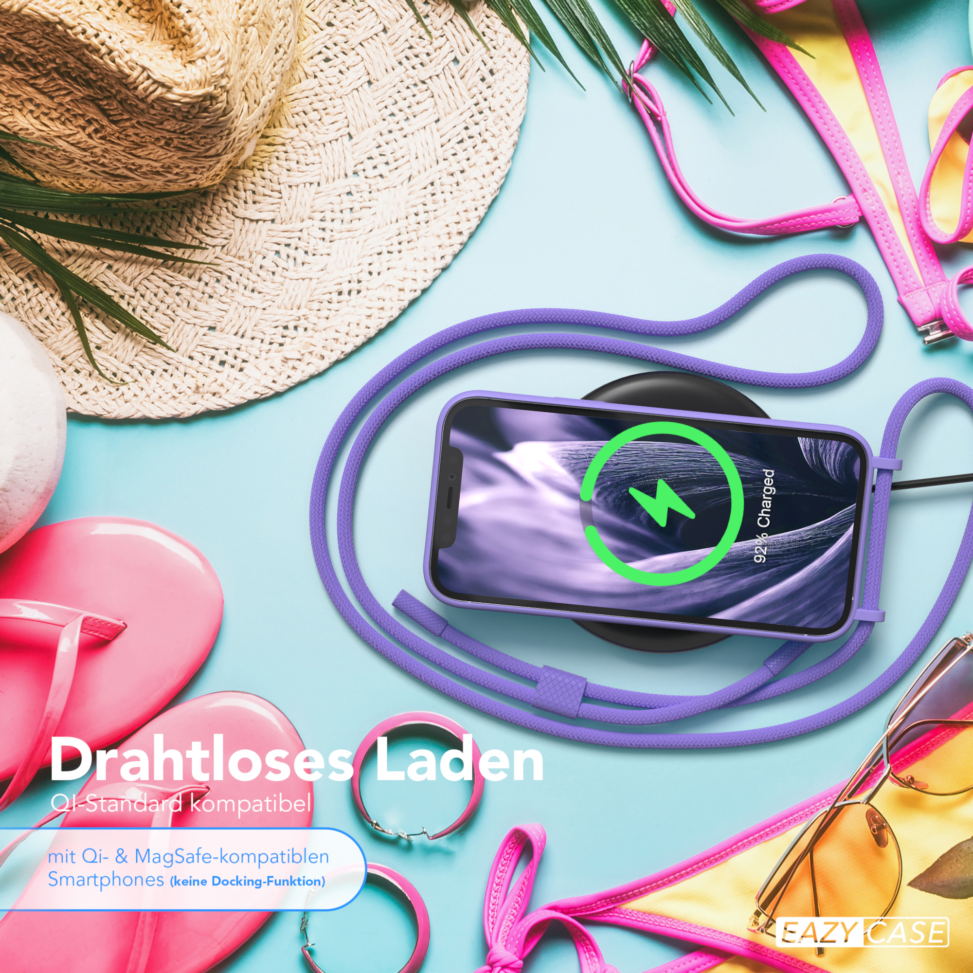 Telefon wird drahtlos auf einem Pad geladen. Strandaccessoires im Hintergrund sichtbar.
