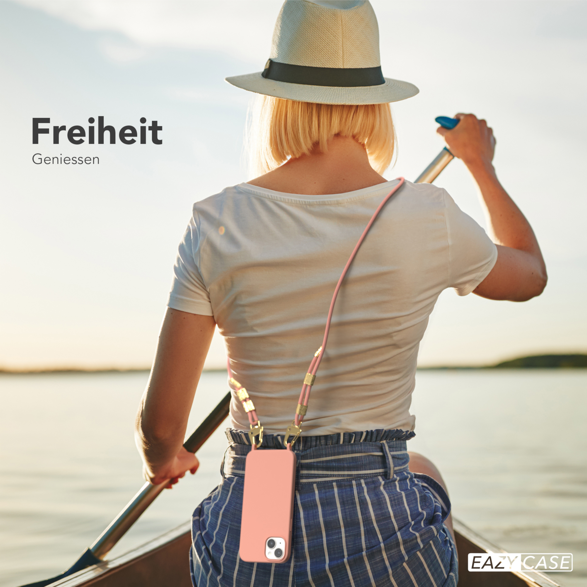 Eine Frau in einem Boot rudert auf dem Wasser und hält ein Telefon mit einer rosa Hülle.