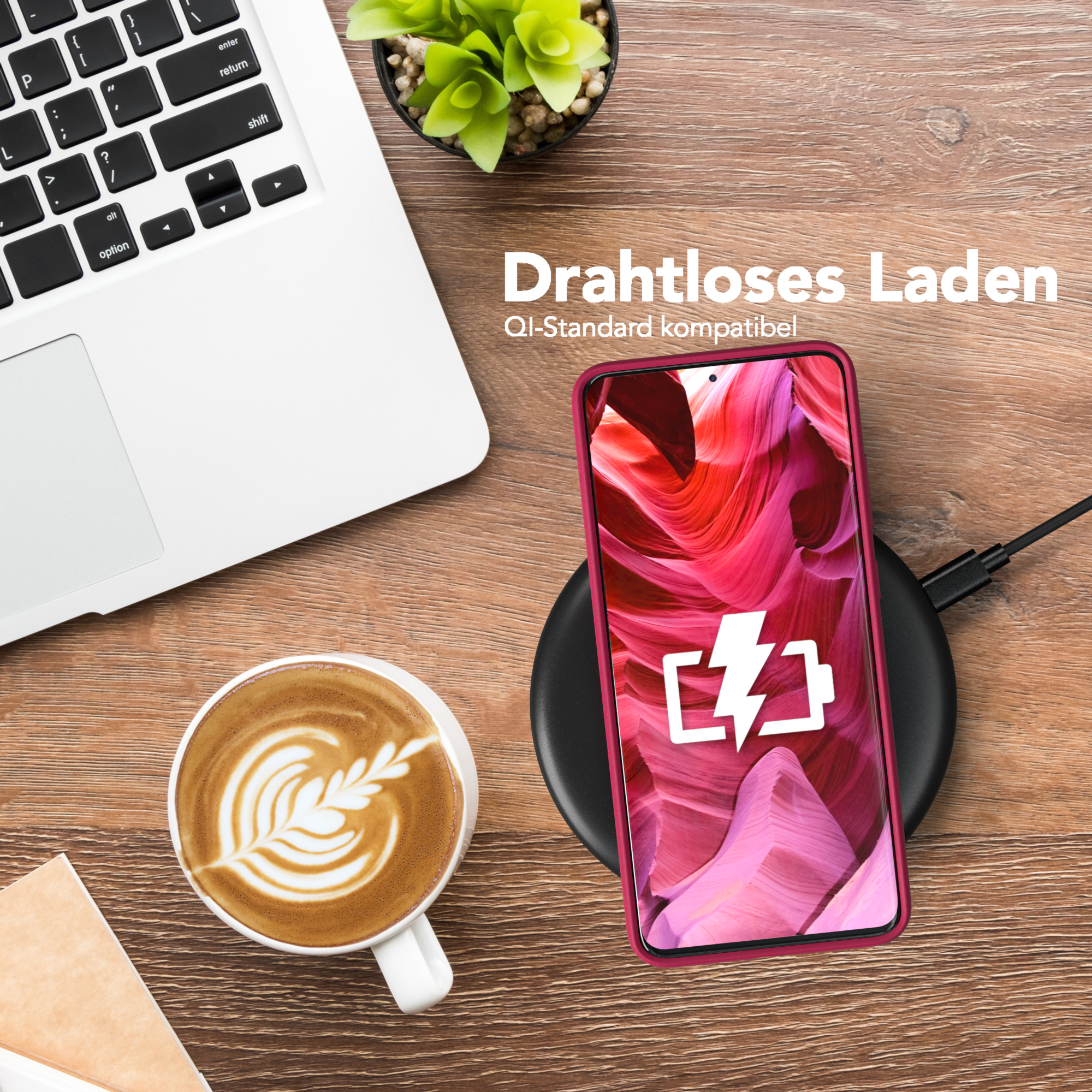 Laptop, Kaffee, Telefon lädt. Telefon zeigt Felsen. Holztisch.