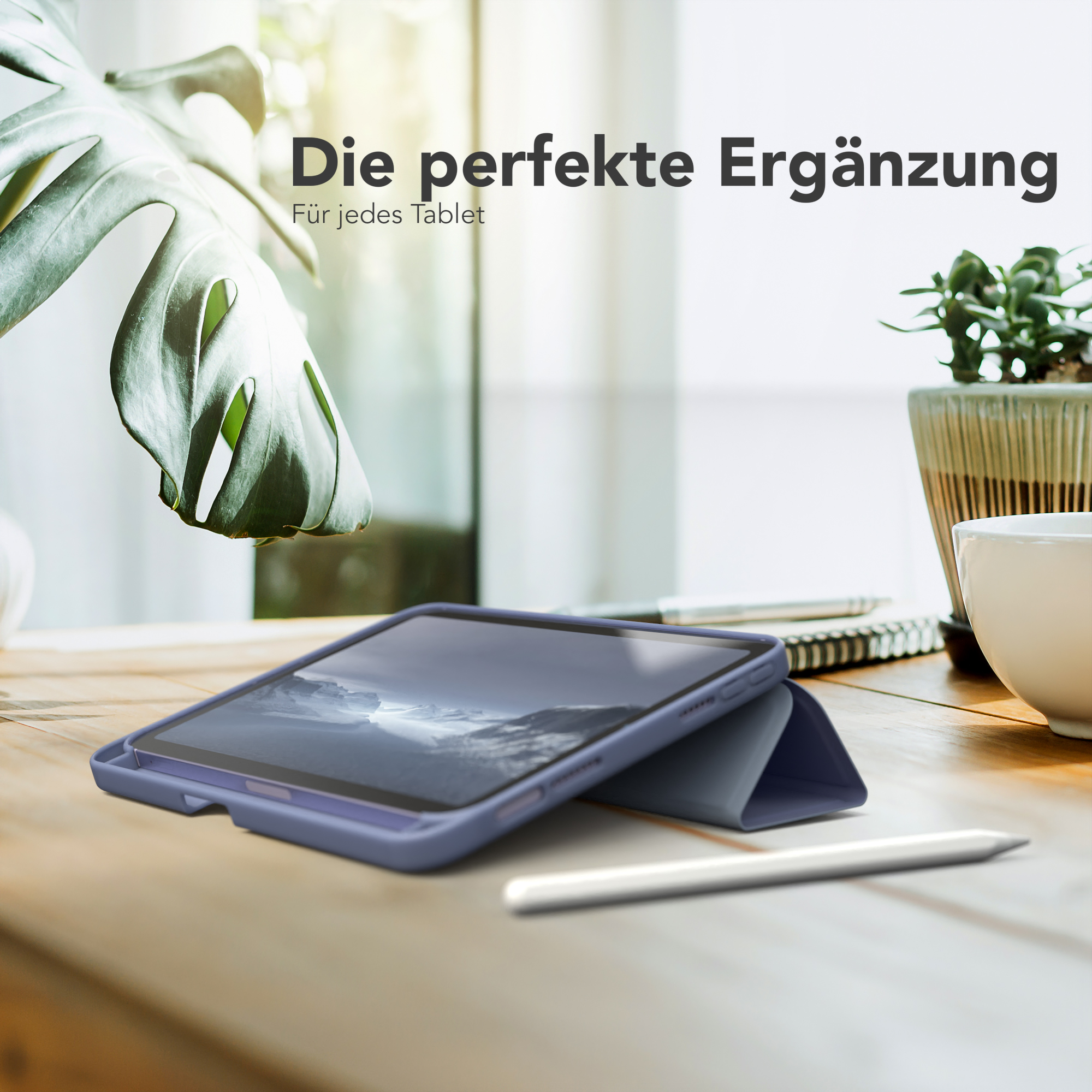 Ein Tablet in einer blauen Hülle auf einem Holztisch, daneben eine Pflanze und ein weißer Stift.