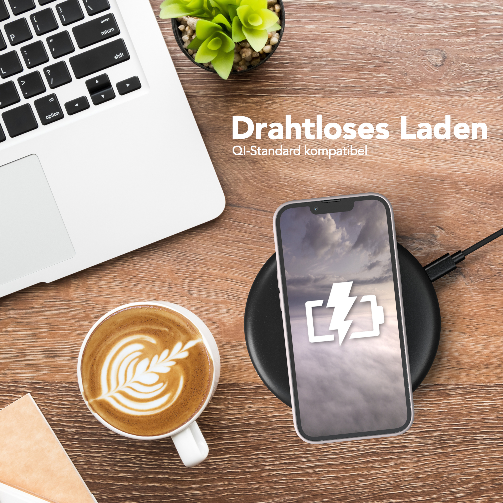 Laptop, Telefon lädt auf Pad und Kaffee auf Holztisch. Text: Kabelloses Laden.