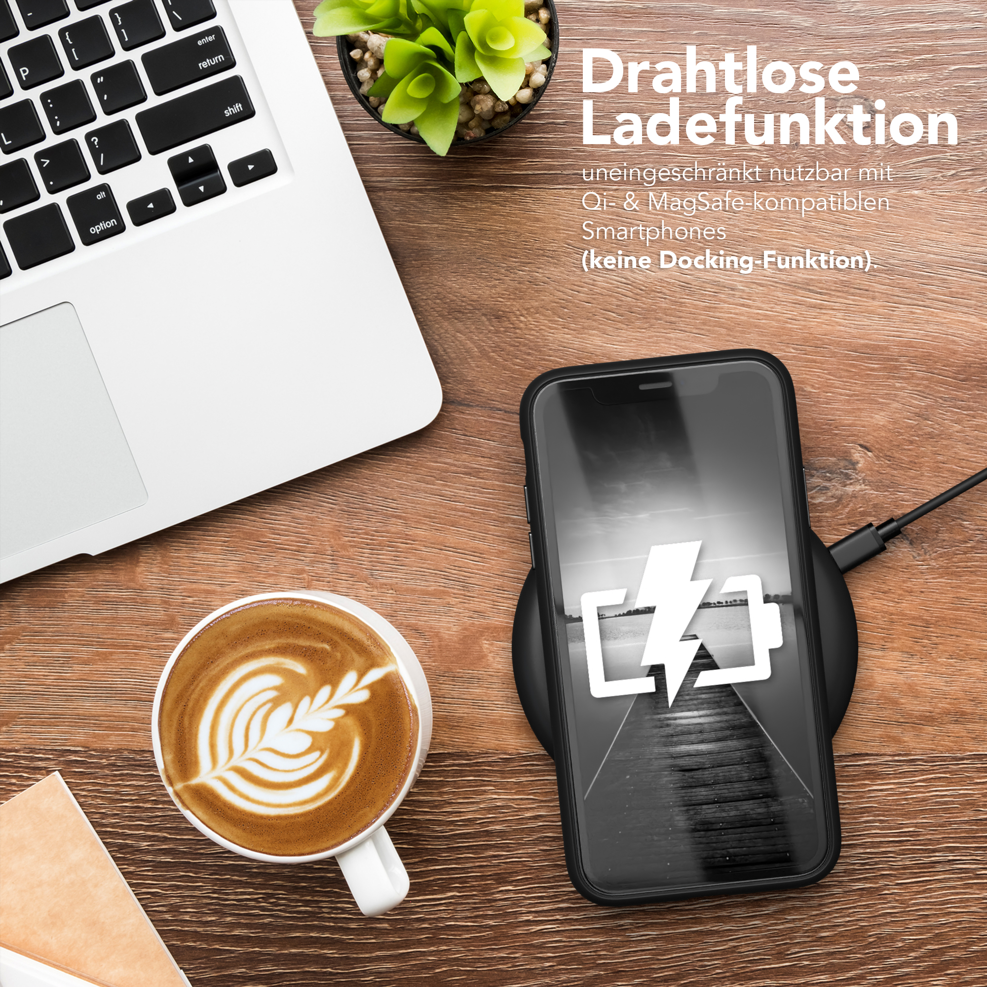 Telefon auf kabellosem Ladegerät. Kaffee, Laptop und Pflanze vorhanden.