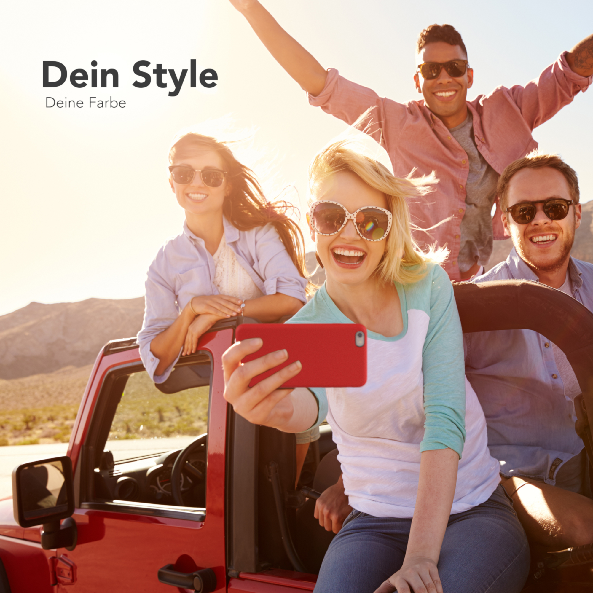 Freundesgruppe in einem roten Jeep, die ein Selfie mit einem roten Telefon macht.