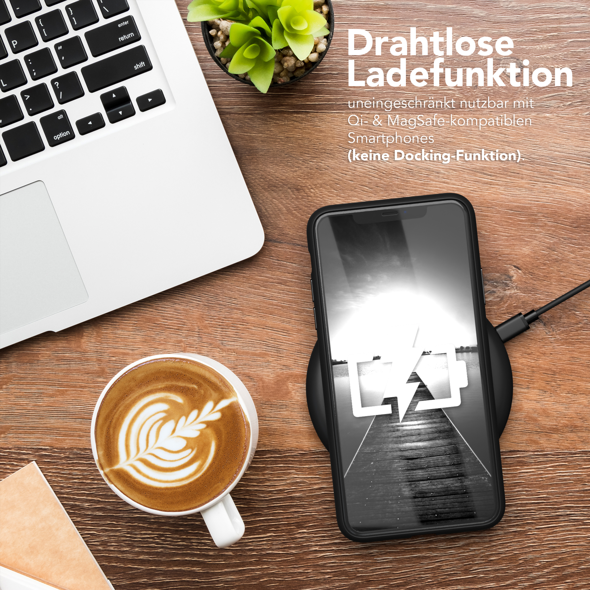 Laptop, Kaffeetasse mit Latte Art und Telefon auf kabellosem Ladegerät auf einem Holzschreibtisch.