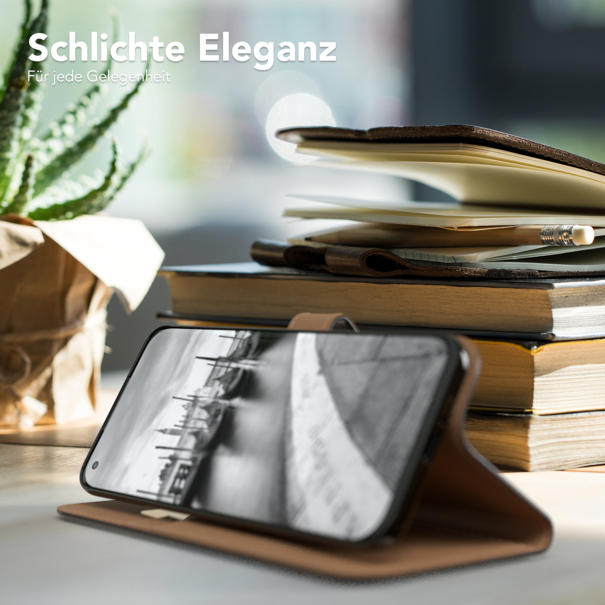 Telefon in brauner Hülle auf Holzschreibtisch. Bücher, Pflanze und Bleistift. Schwarz-Weiß-Bildschirm.