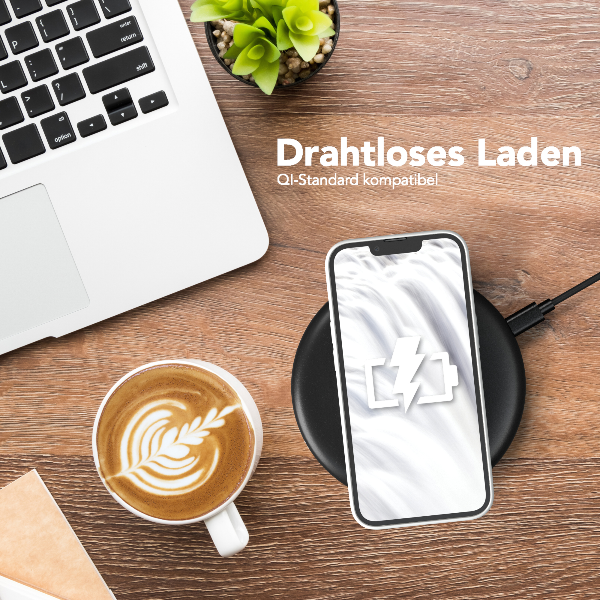 Telefon kabellos auf einem Pad laden, mit Laptop, Kaffee und Pflanze im Hintergrund.