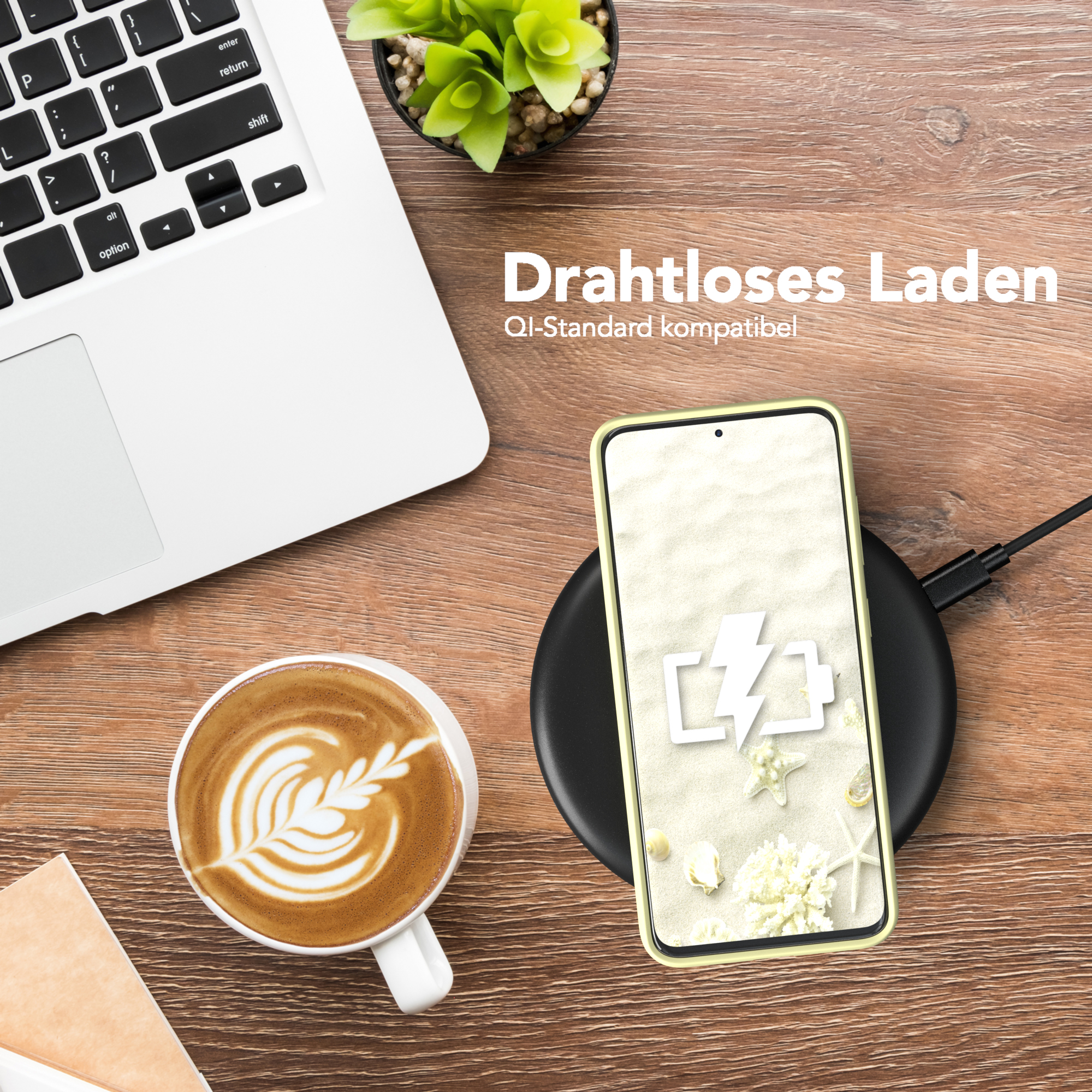 Telefon auf kabellosem Ladegerät, mit Laptop, Kaffeetasse und Pflanze auf einem Holztisch.