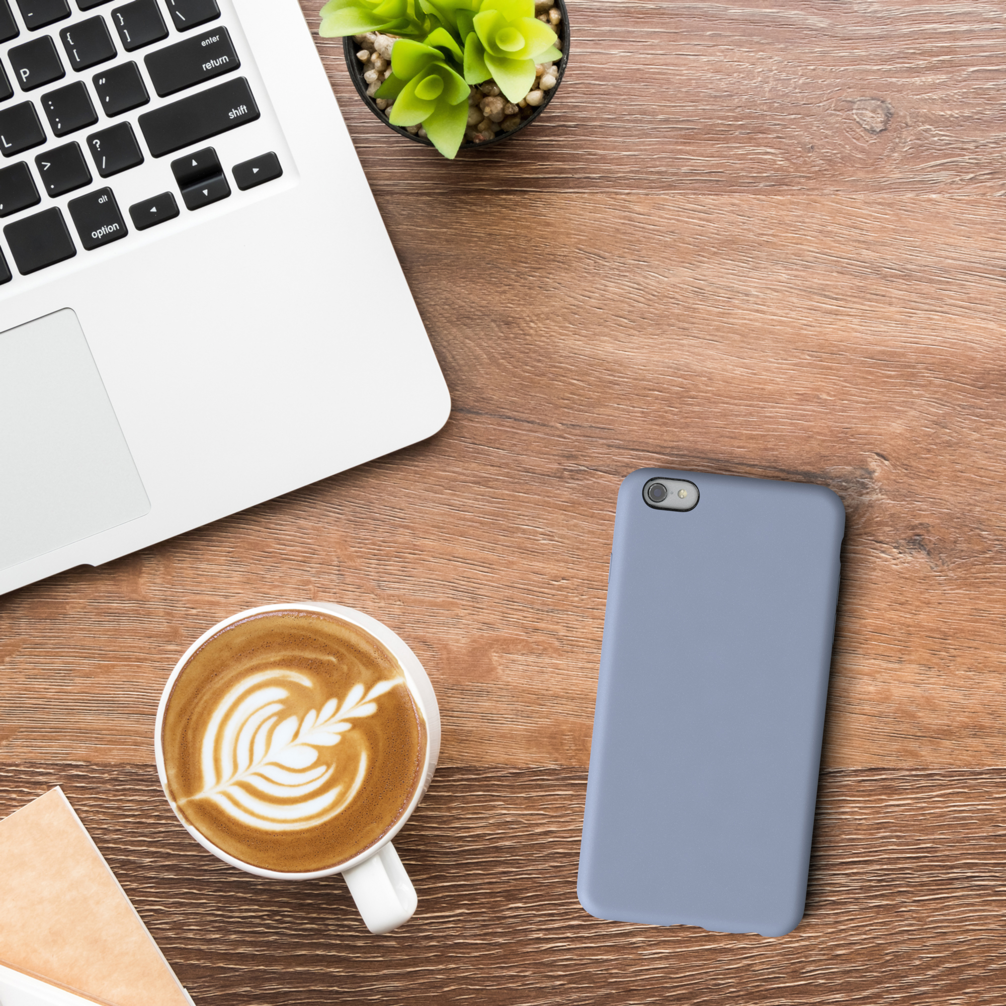 Laptop, Kaffee, Handyhülle. Holztisch. Das Telefon ist blau.