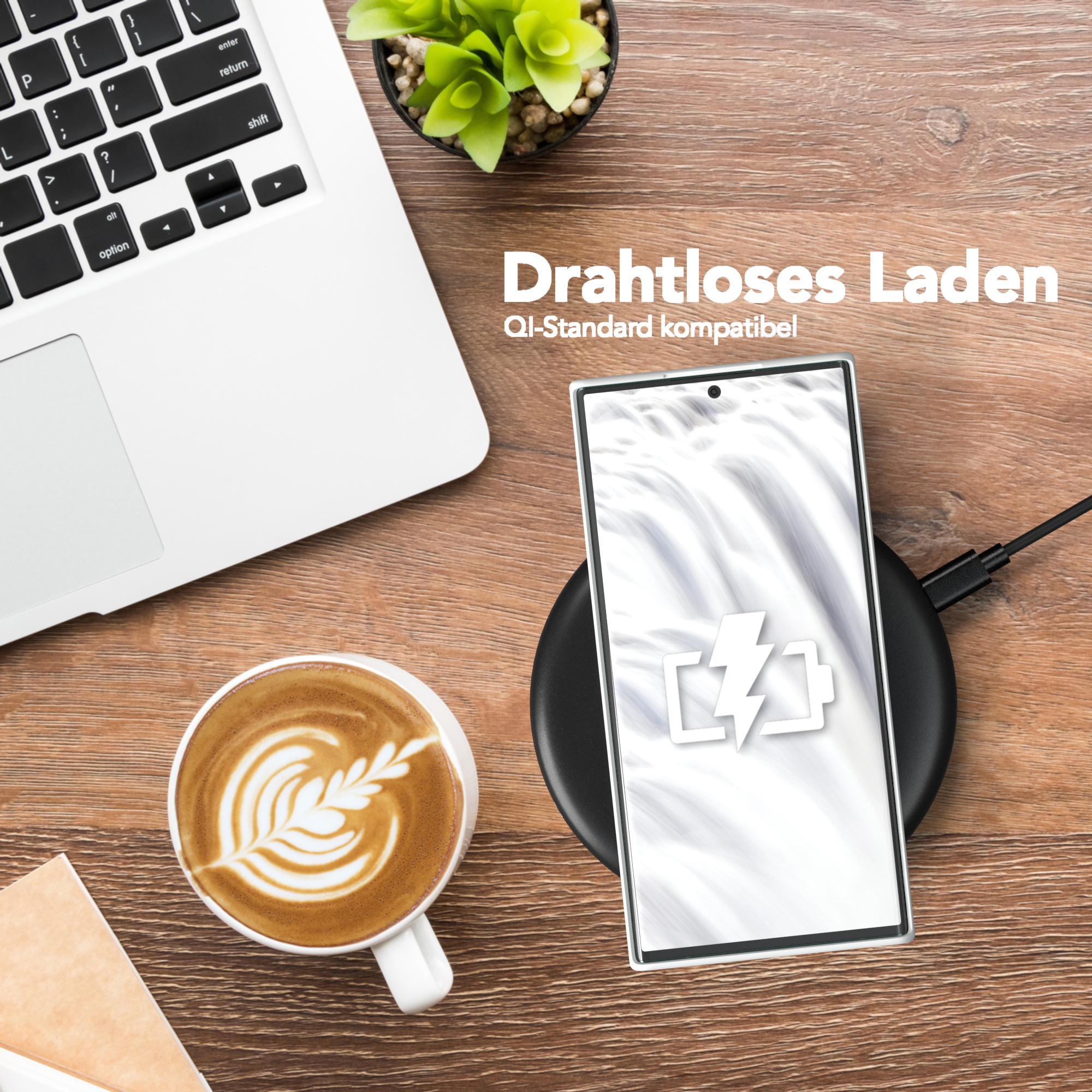 Telefon wird kabellos auf einem Pad geladen, neben Kaffee und Laptop.