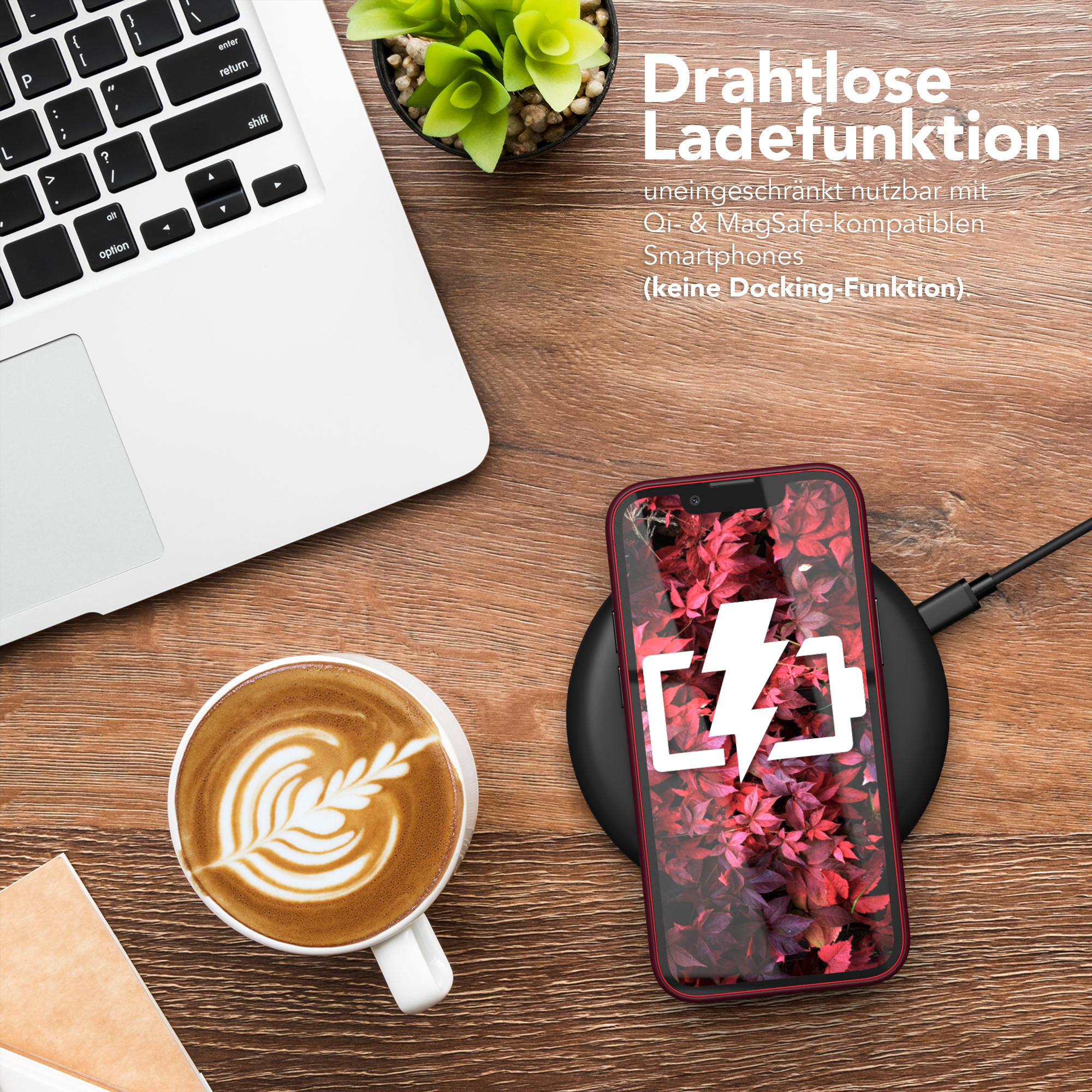 Laptop, Kaffee mit Latte Art und ein Telefon, das auf einem kabellosen Ladegerät lädt.