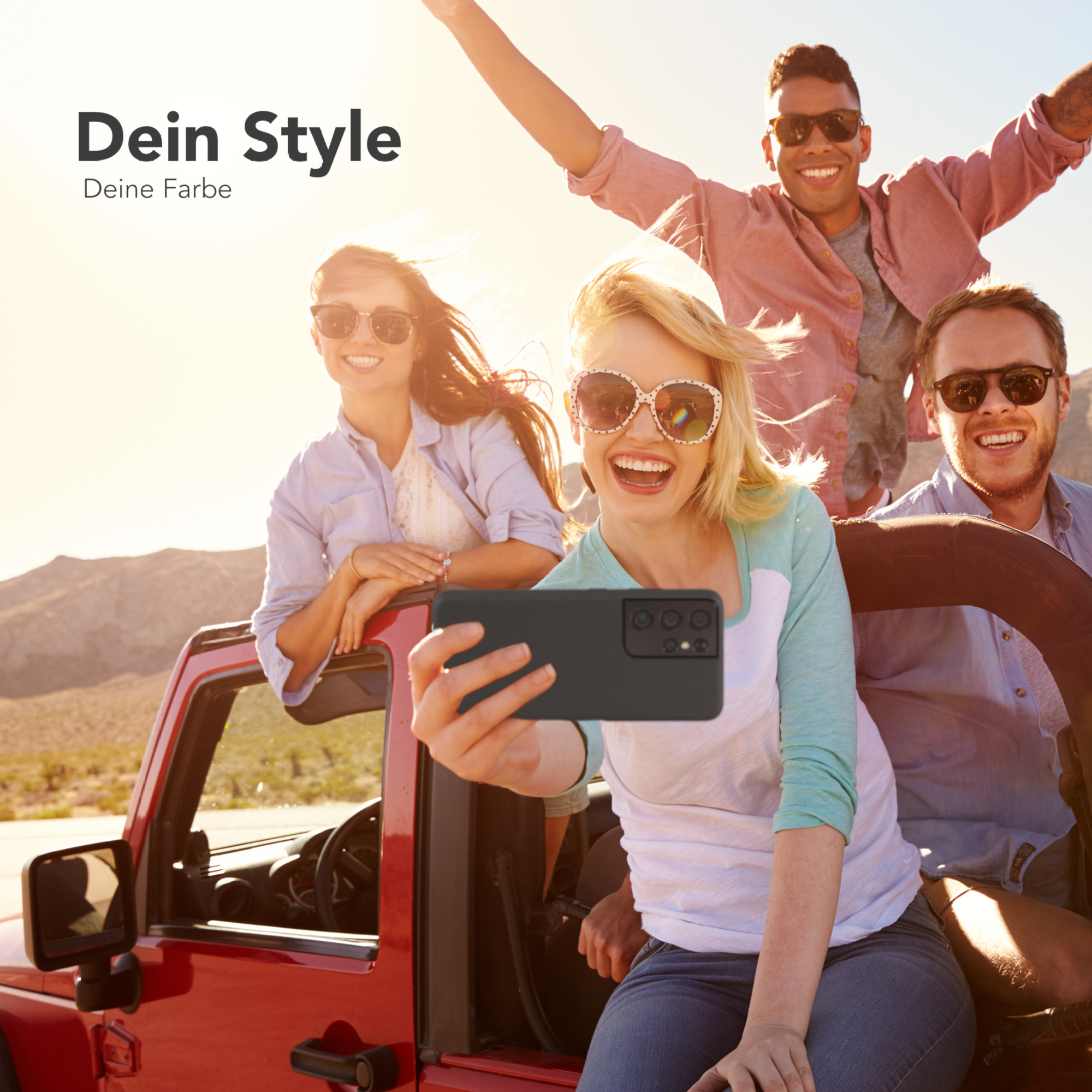 Gruppe von vier Personen macht ein Selfie mit einem Telefon in einem roten Jeep.