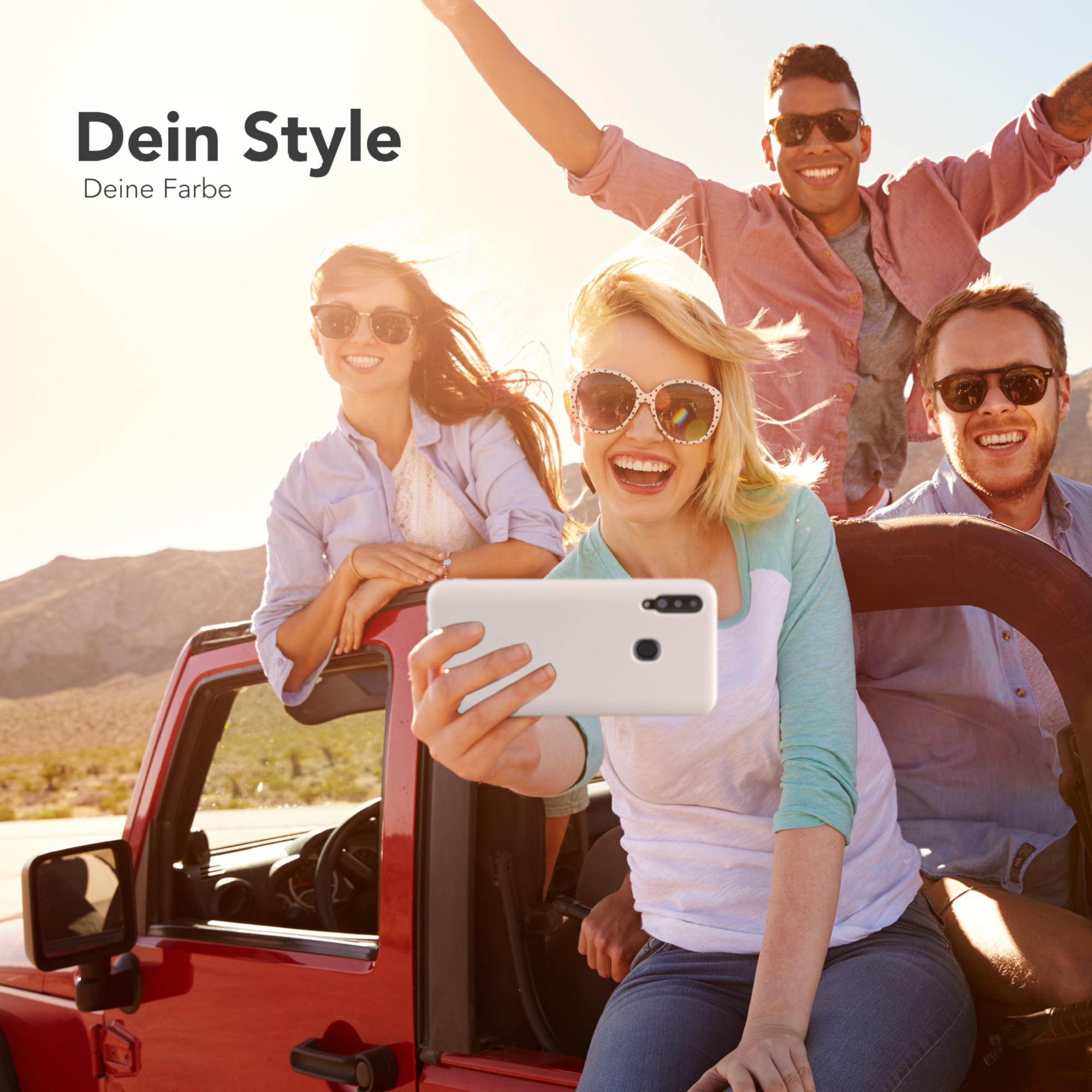 Freundesgruppe in einem roten Jeep macht ein Selfie. Sonniger Tag, Landschaft im Hintergrund.
