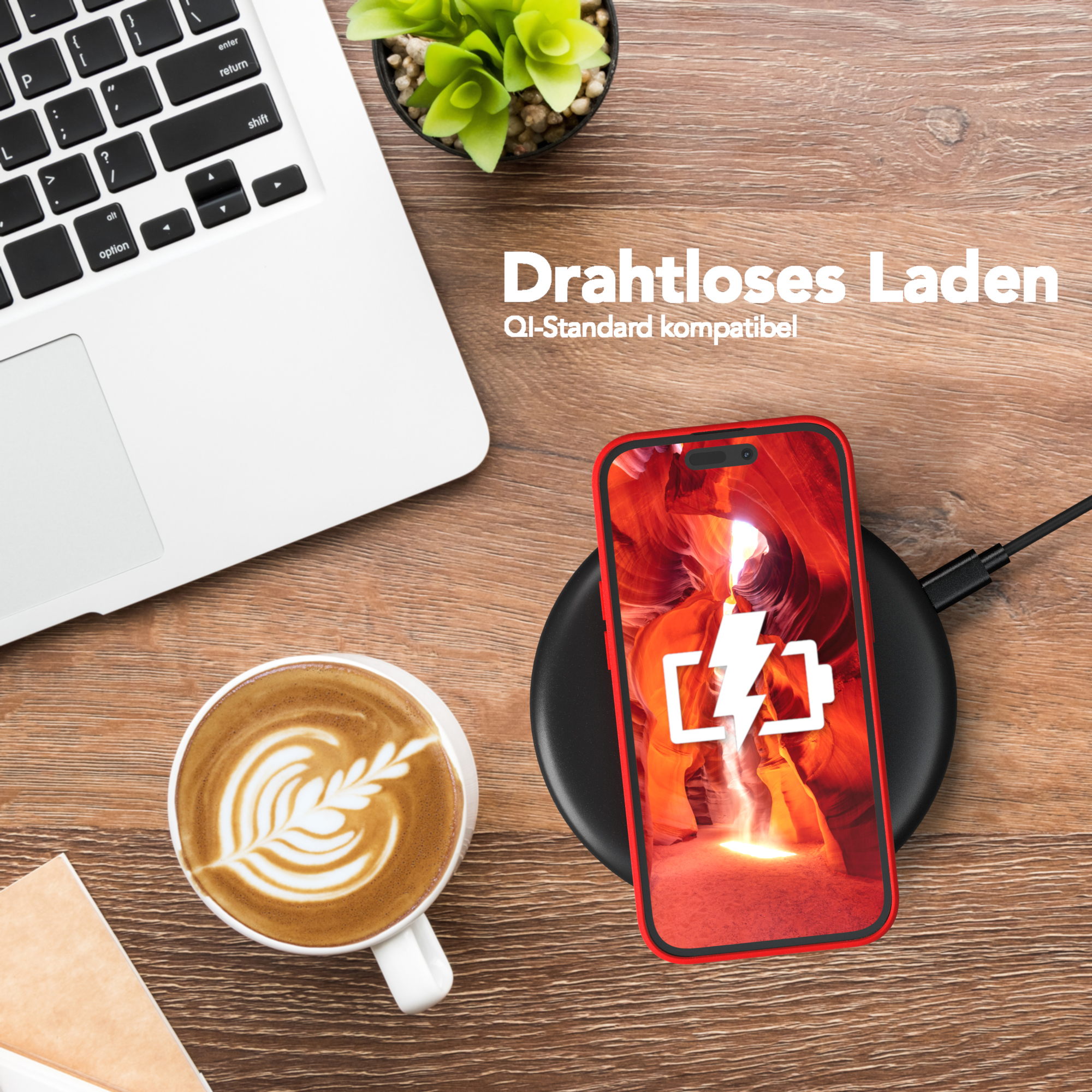 Telefon auf kabellosem Ladegerät, neben Laptop und Kaffee mit Latte Art.