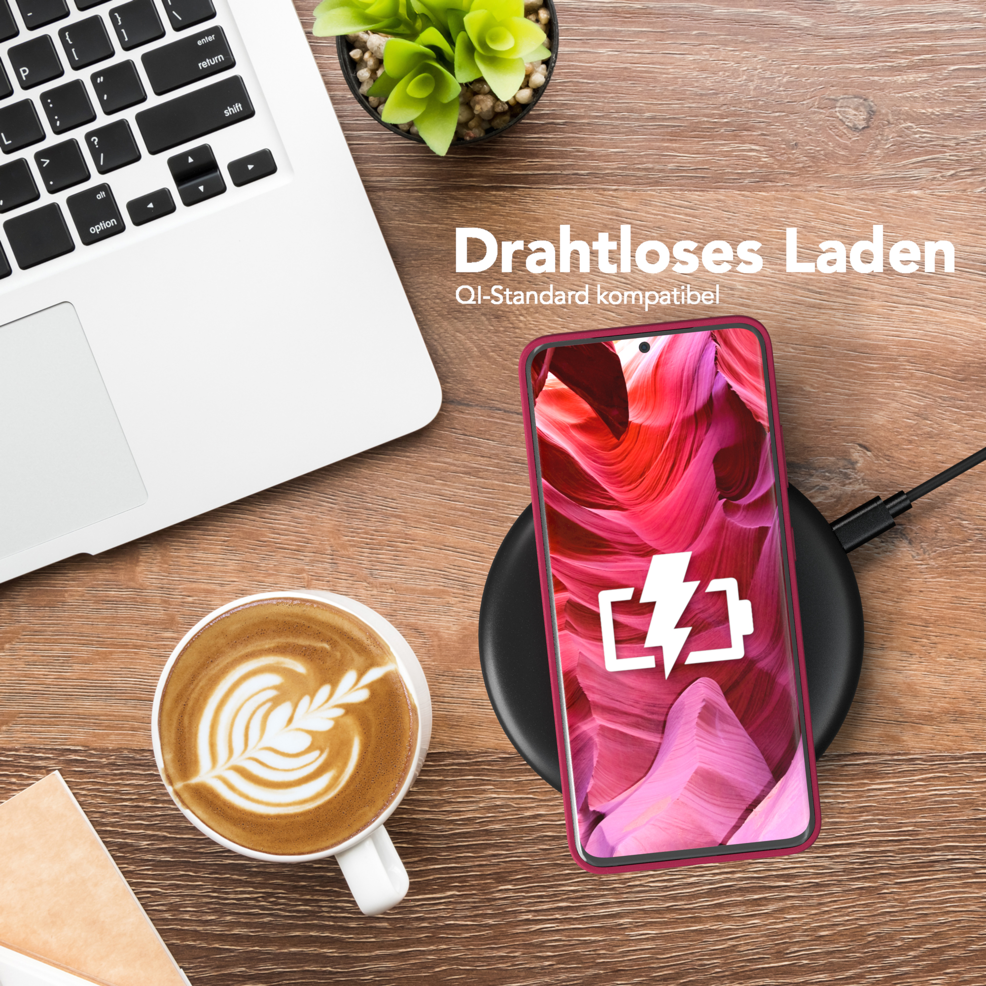 Laptop, Telefon auf Ladegerät, Kaffee. Der Telefonbildschirm hat ein rotes und rosa Muster.