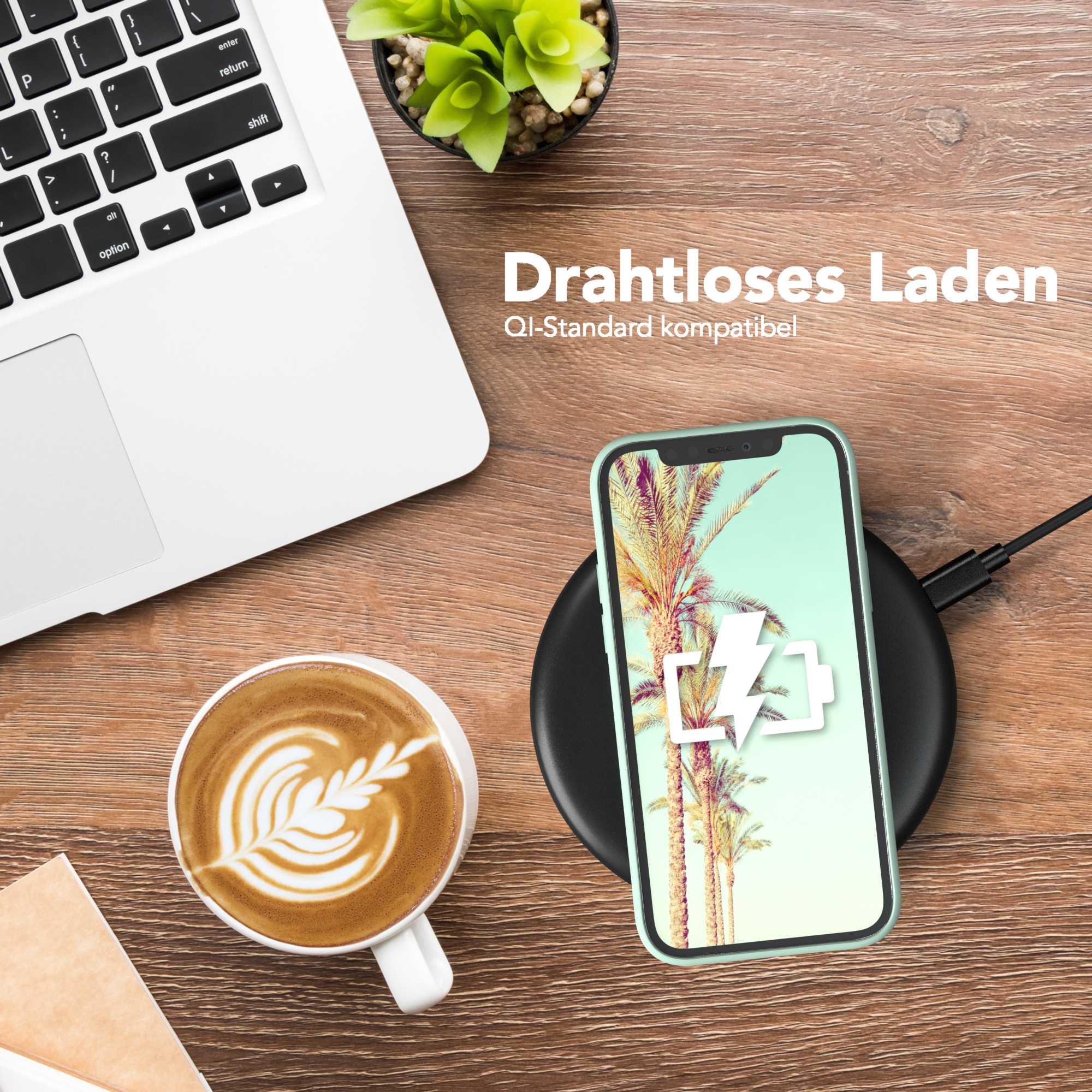 Telefon auf kabellosem Ladegerät, neben Laptop und Kaffeetasse. Telefon zeigt Palmen.