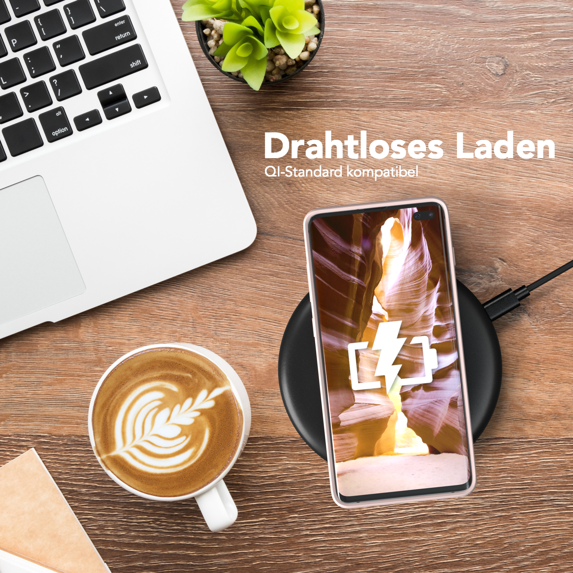 Ein Telefon wird kabellos auf einem Holztisch geladen. Laptop und Kaffee im Bild.
