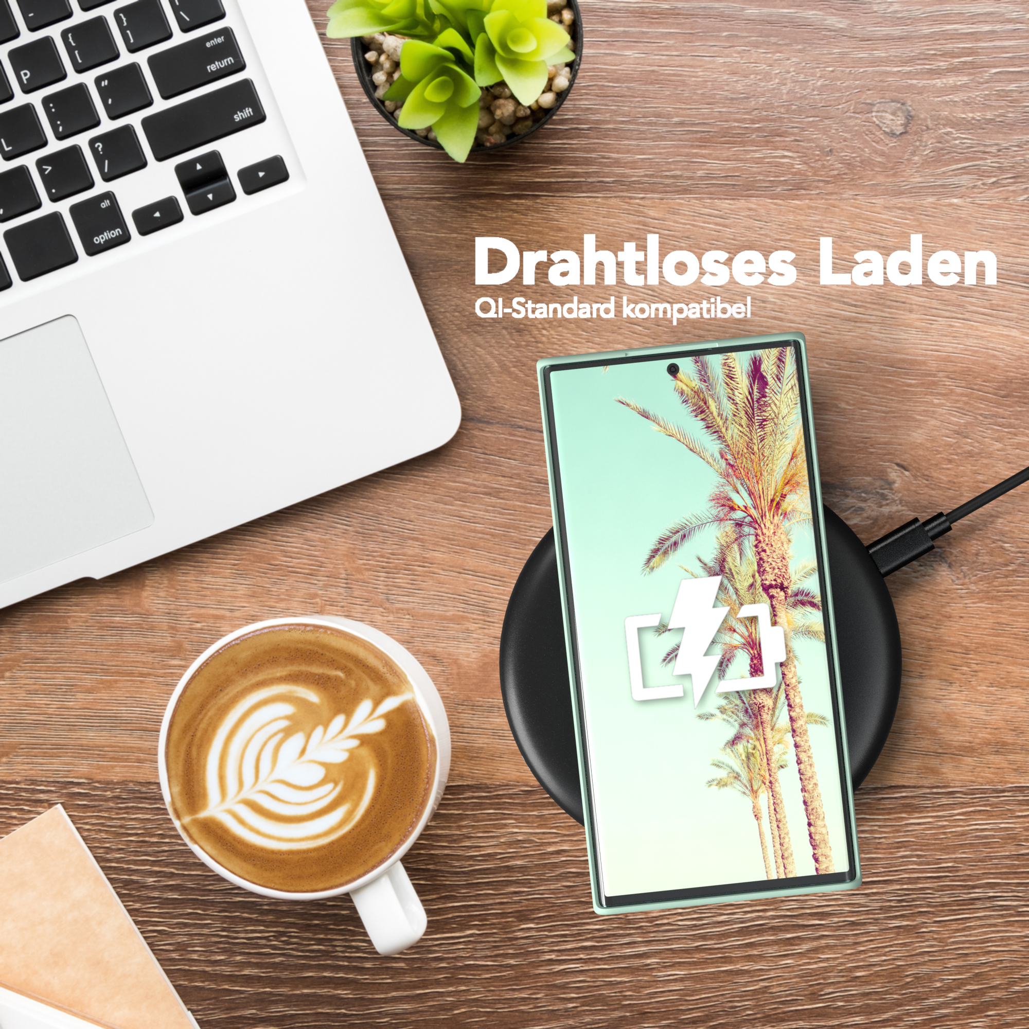 Telefon auf kabellosem Ladegerät, mit Laptop, Kaffee und Pflanze auf Holzoberfläche.