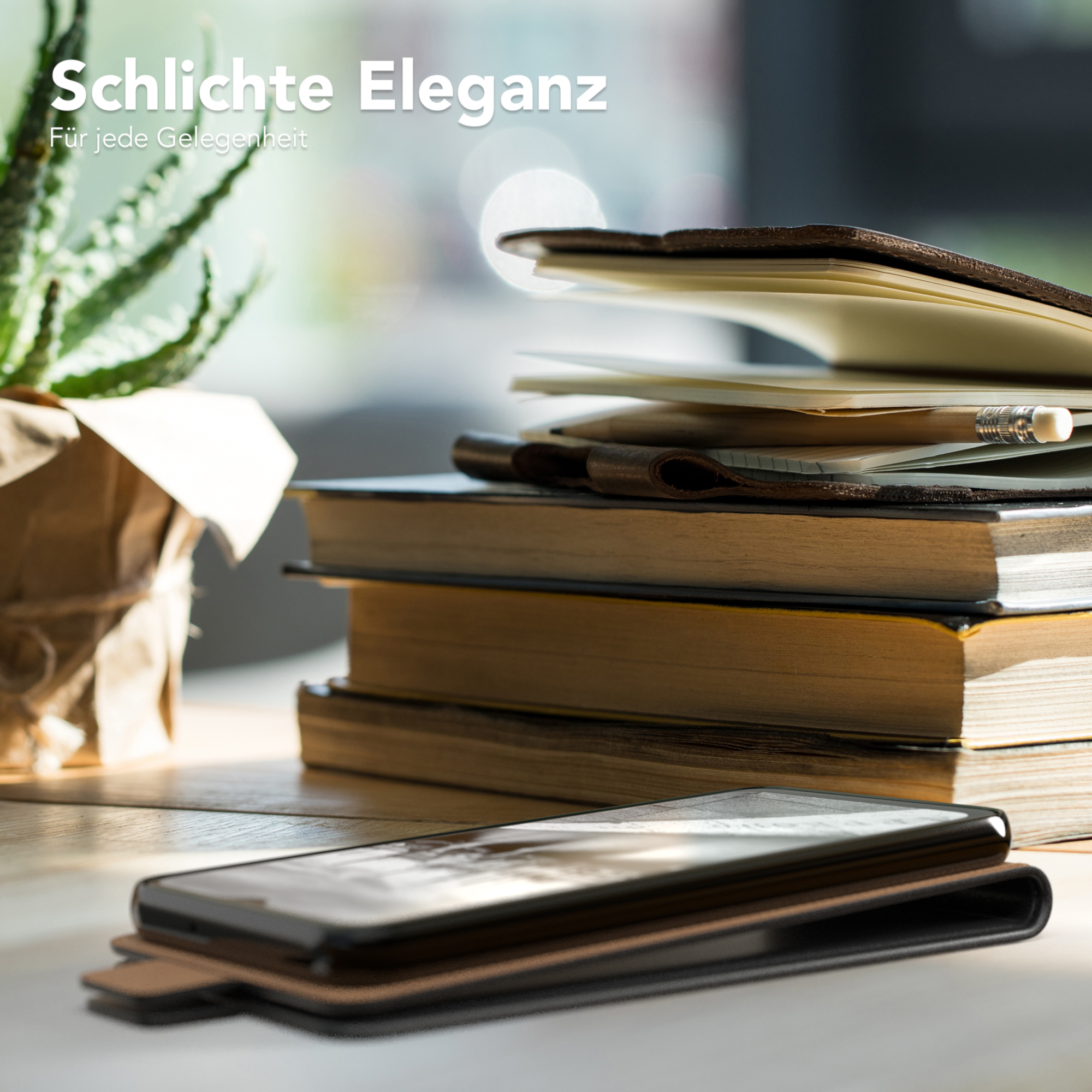 Eine Handyhülle auf einem Holztisch mit Büchern, einer Pflanze und einem Notizbuch.