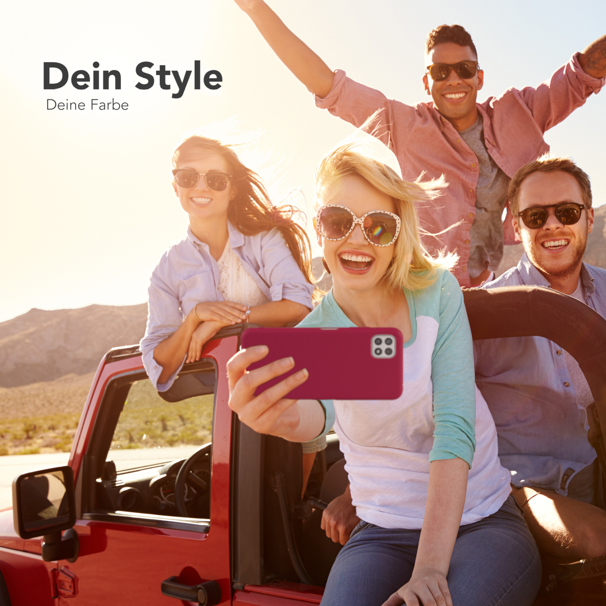 Eine Gruppe von Freunden macht ein Selfie. Eine Person hält ein Telefon mit roter Hülle. Die Sonne geht unter.