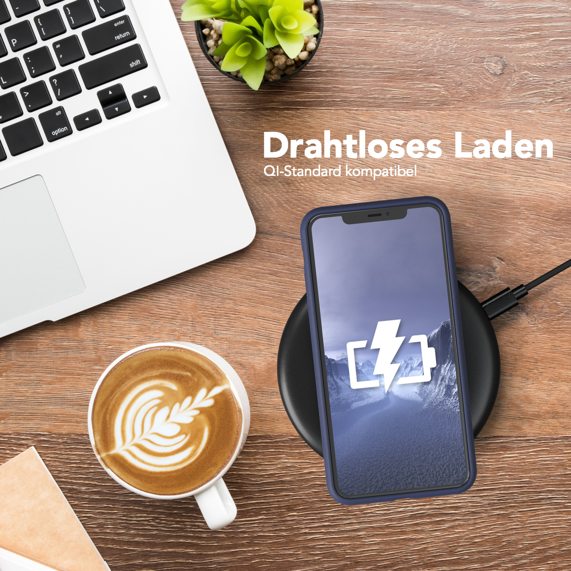 Telefon auf einem kabellosen Ladegerät neben einem Laptop und einer Kaffeetasse.