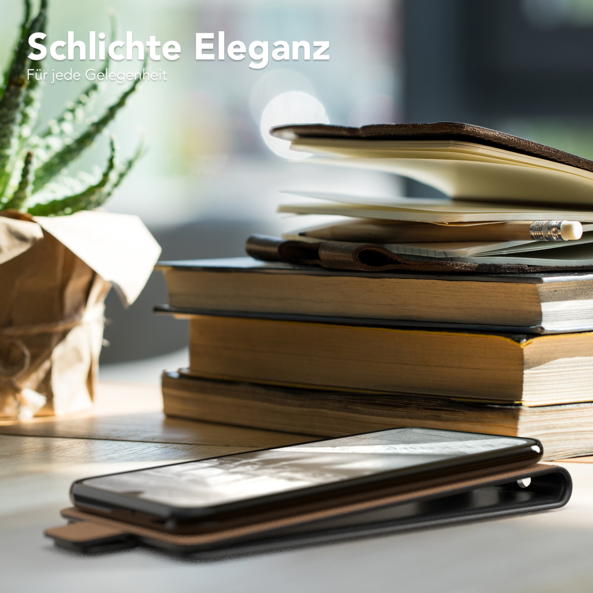 Handyhülle mit Telefon auf einem Tisch mit Büchern und einer Pflanze.