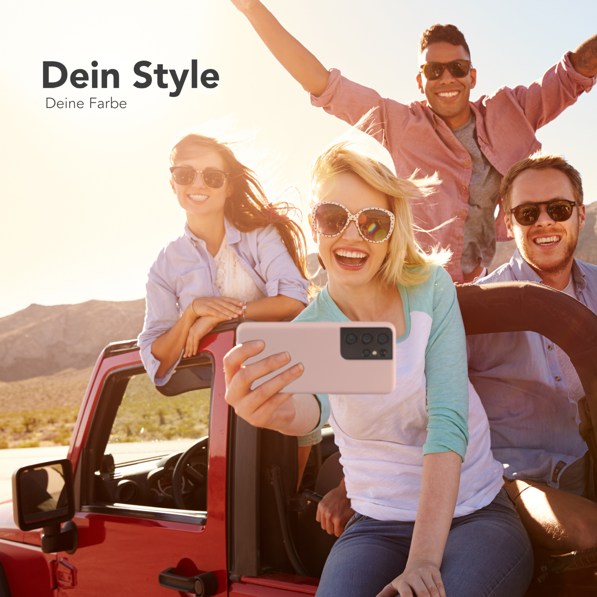 Vier Personen in einem roten Jeep lächeln. Einer macht ein Selfie mit einer pinkfarbenen Handyhülle.